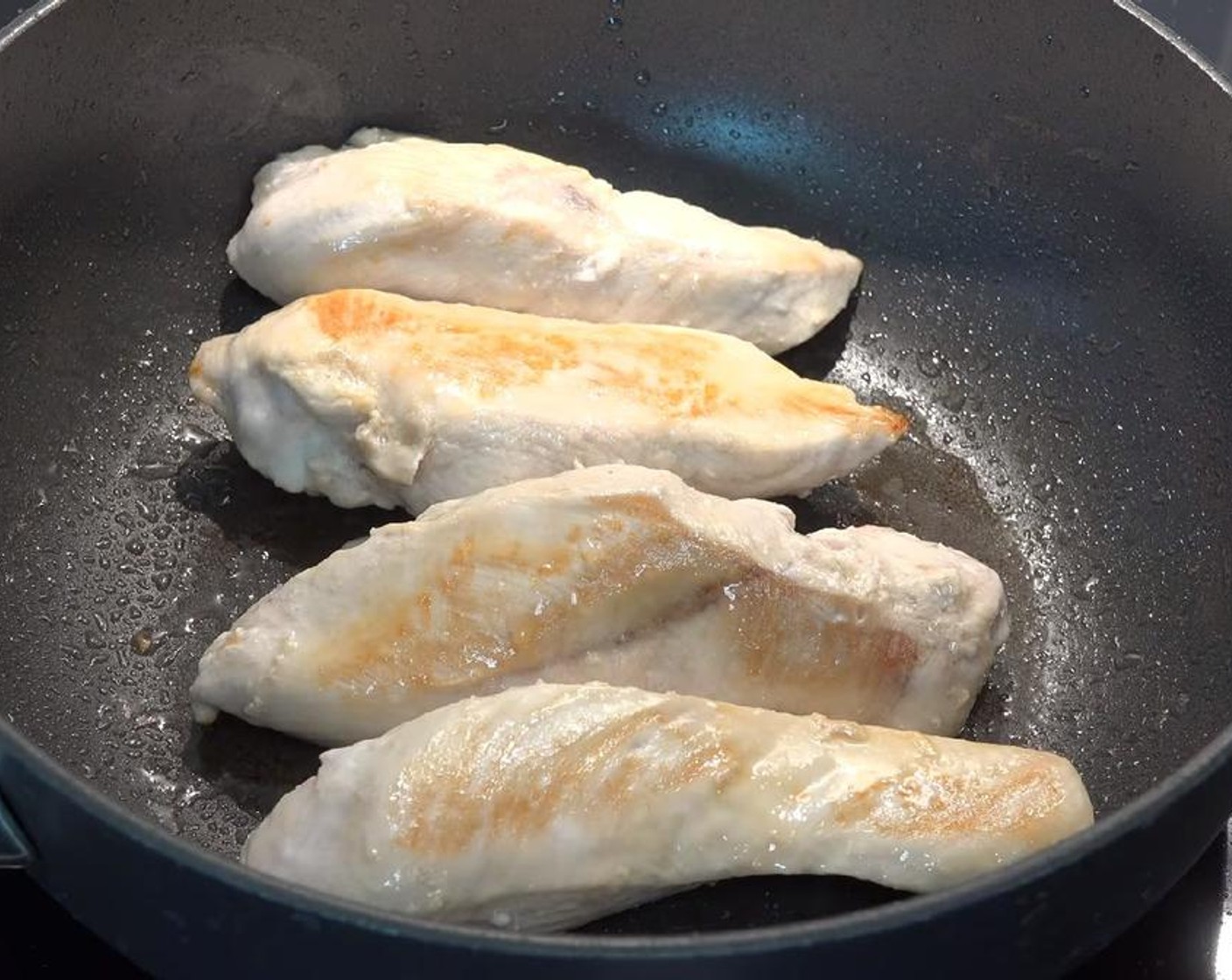 step 2 Pour Olive Oil (as needed) into a large deep fry pan over medium heat. Brown the Chicken Breasts (2). Let it rest for a few minutes, then slice the chicken into chunks.