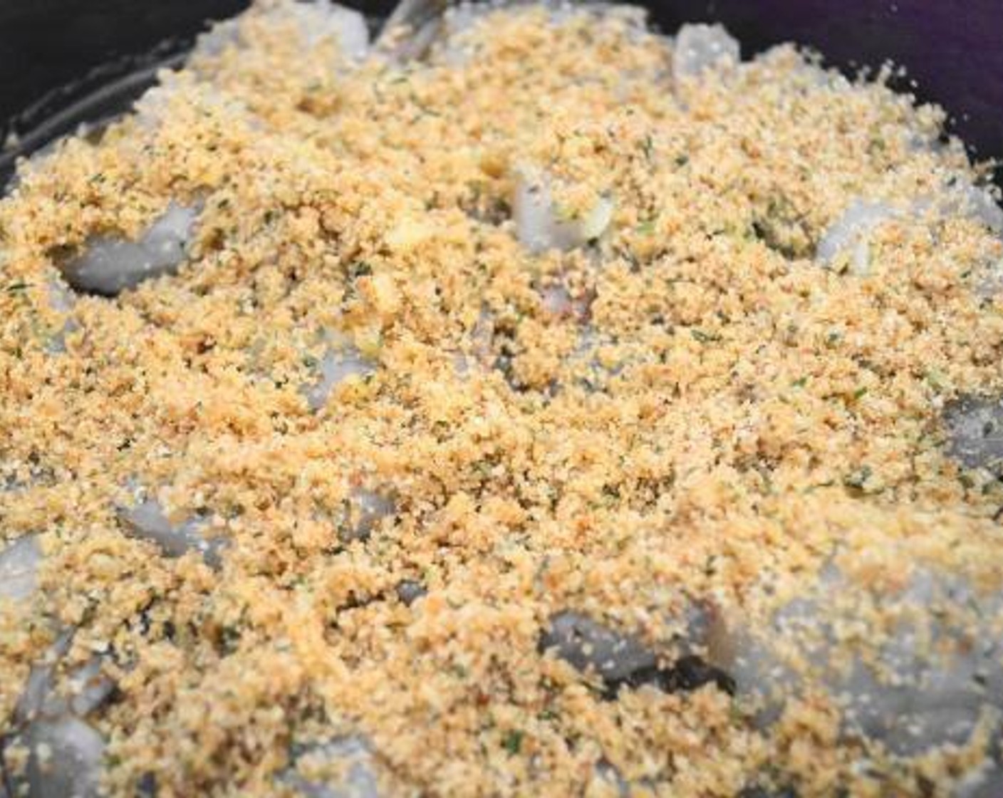 step 5 Layout​ the Large Shrimp (1 lb) in a baking dish and pour the remaining butter mixture all over them. Spoon the buttery breadcrumbs on top of the shrimp, then bake them for about 10-12 minutes.