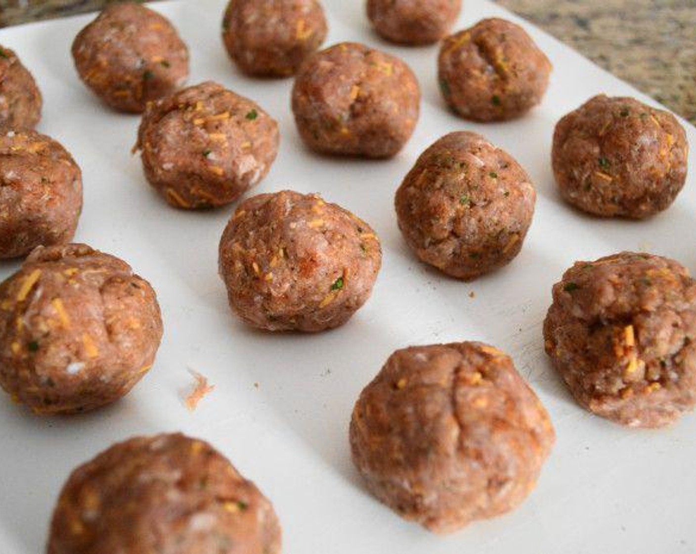 step 2 With clean hands mix it together thoroughly. Scoop out two tablespoons of the mixture and roll it into a tight ball, then set it aside on a lined tray or board. Repeat with the rest of the mixture until it is gone, yielding 16 meatballs.