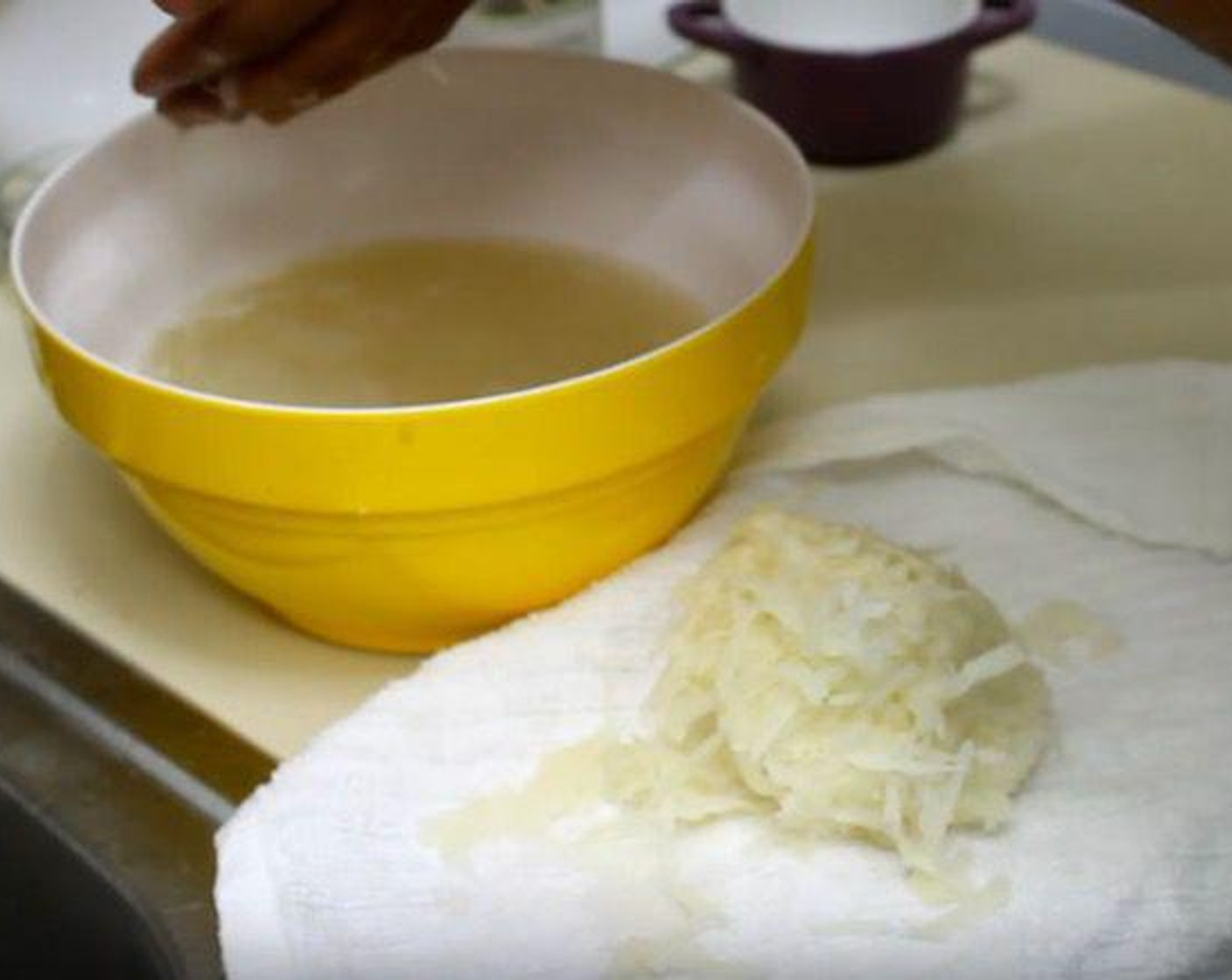 step 1 Into a cold bowl of water, shred the Russet Potato (1 lb) and Yellow Onion (1/2). With your hands, squeeze the contents of the bowl and mix them around until the water is cloudy. Remove the potatoes and onion, one handful at a time, squeezing out excess water and transferring to a paper towel. Return to a dry bowl.