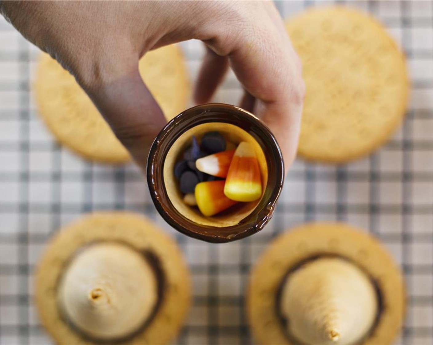 step 4 Working quickly, fill the cone with Candy Corn (2 cups) and seal with a biscuit. Place the hats back on the wire rack.