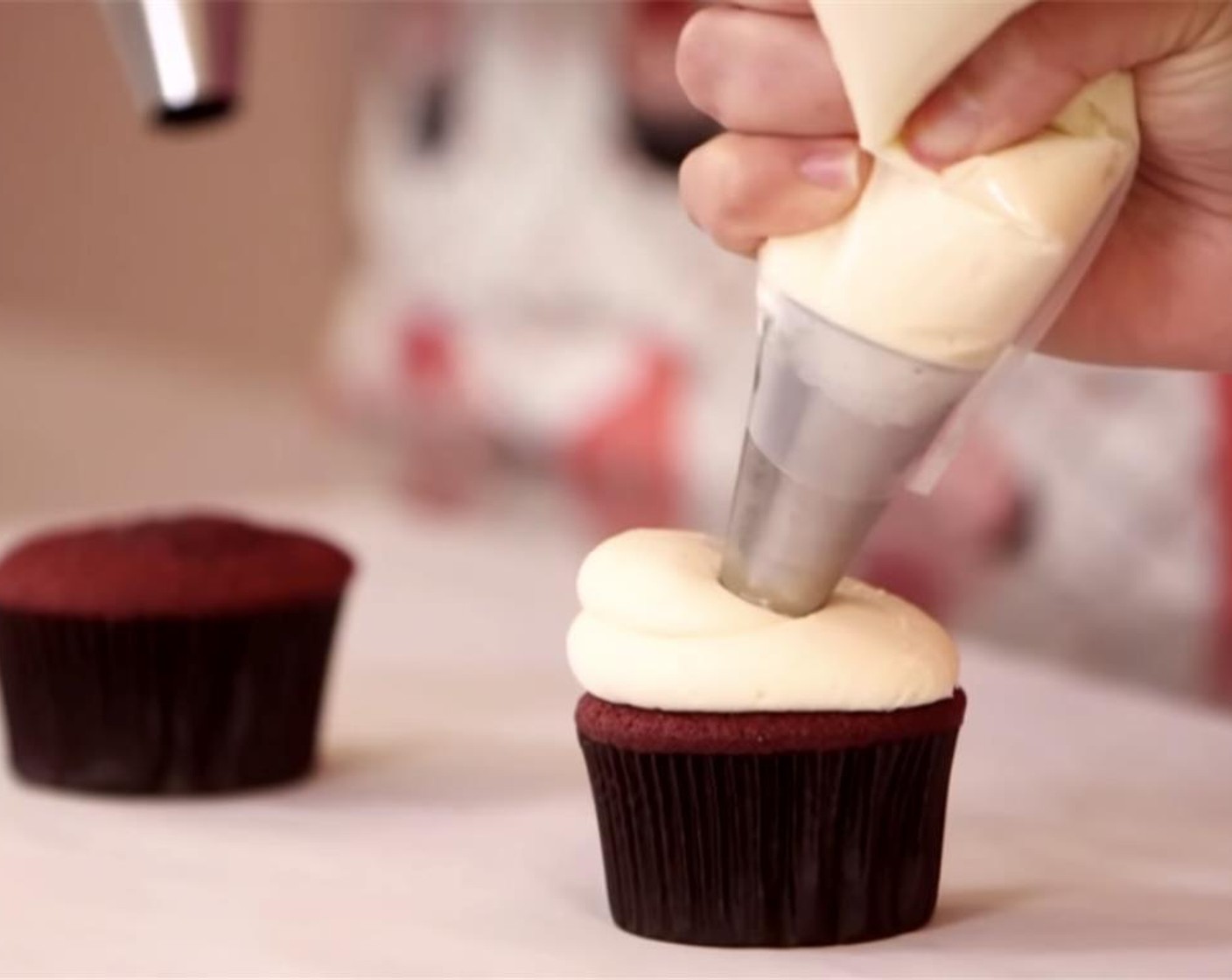 step 15 Transfer frosting into a plastic piping bag fitted with a round metal tip. Make sure cupcakes are completely cooled before piping the frosting on each cupcake.