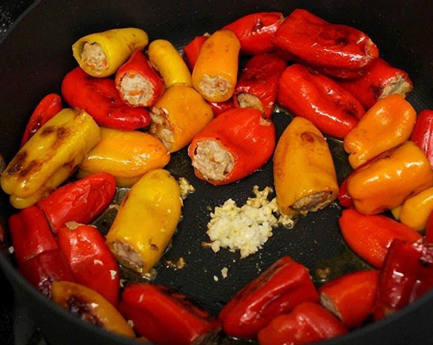 step 9 Make room in the center and add Garlic (2 cloves). Cook for 30 seconds or so and pour in the Diced Tomatoes (1 can)