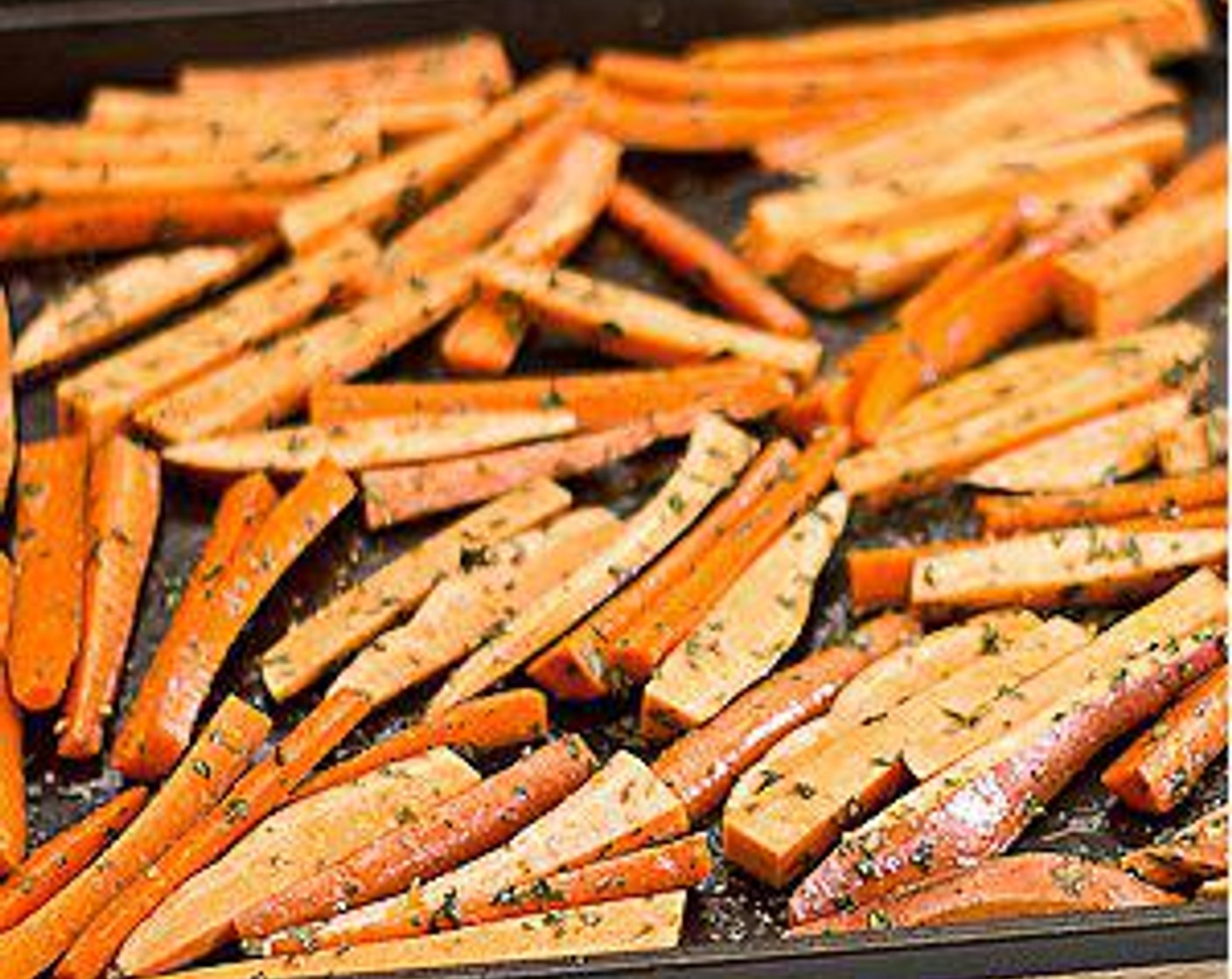 step 3 In a large baking sheet, toss carrots and sweet potatoes with Olive Oil (2 Tbsp), Dried Mixed Herbs (2 Tbsp), Salt (1 tsp), and Ground Black Pepper (1/2 tsp).