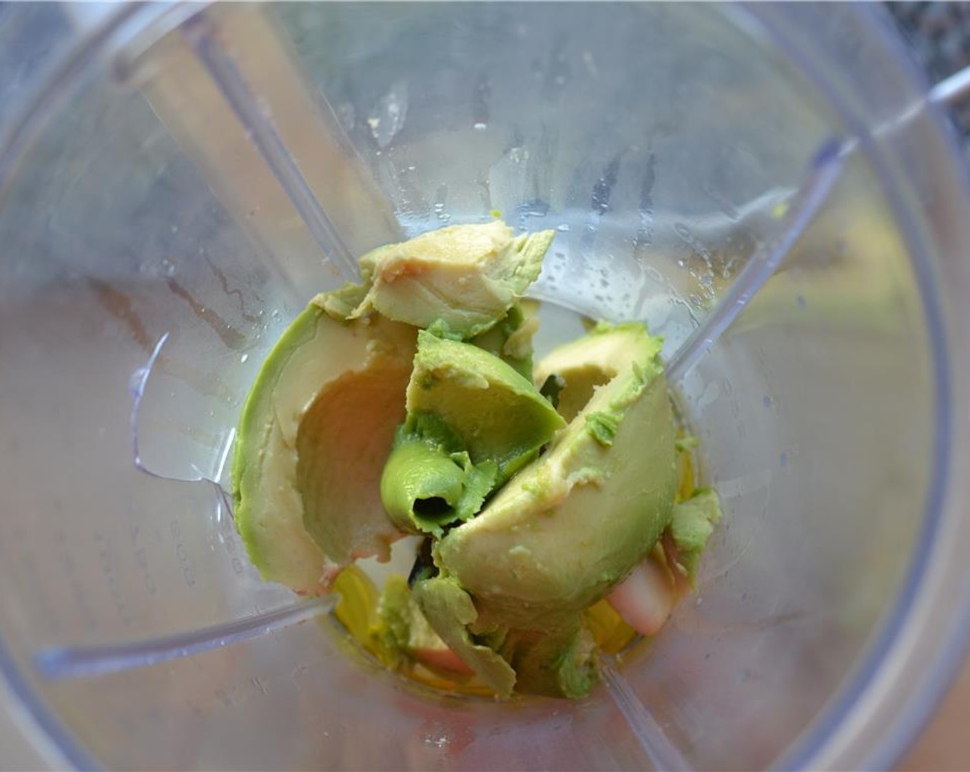 step 4 Put Olive Oil (2 Tbsp), Salt (1/2 tsp), garlic clove and the flesh of the avocado into a blender.