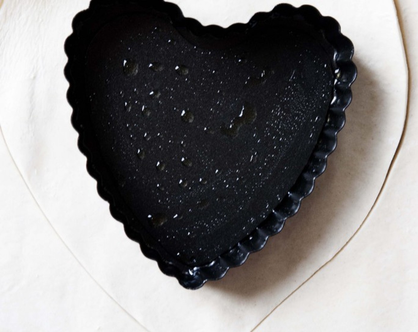 step 10 Grab one of these cute heart shape pan. Roll out the puff pastry sheet, and cut it out into 2 big hearts. Place one into the pan, pressing well around the edges.