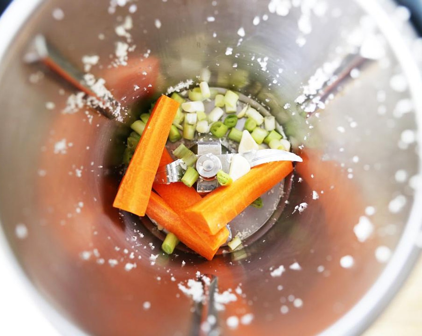 step 2 Add the Carrot (1/2), Garlic (1 clove), and white part of the Scallions (2) to the Thermomix and blend on speed 5 for 5 seconds.