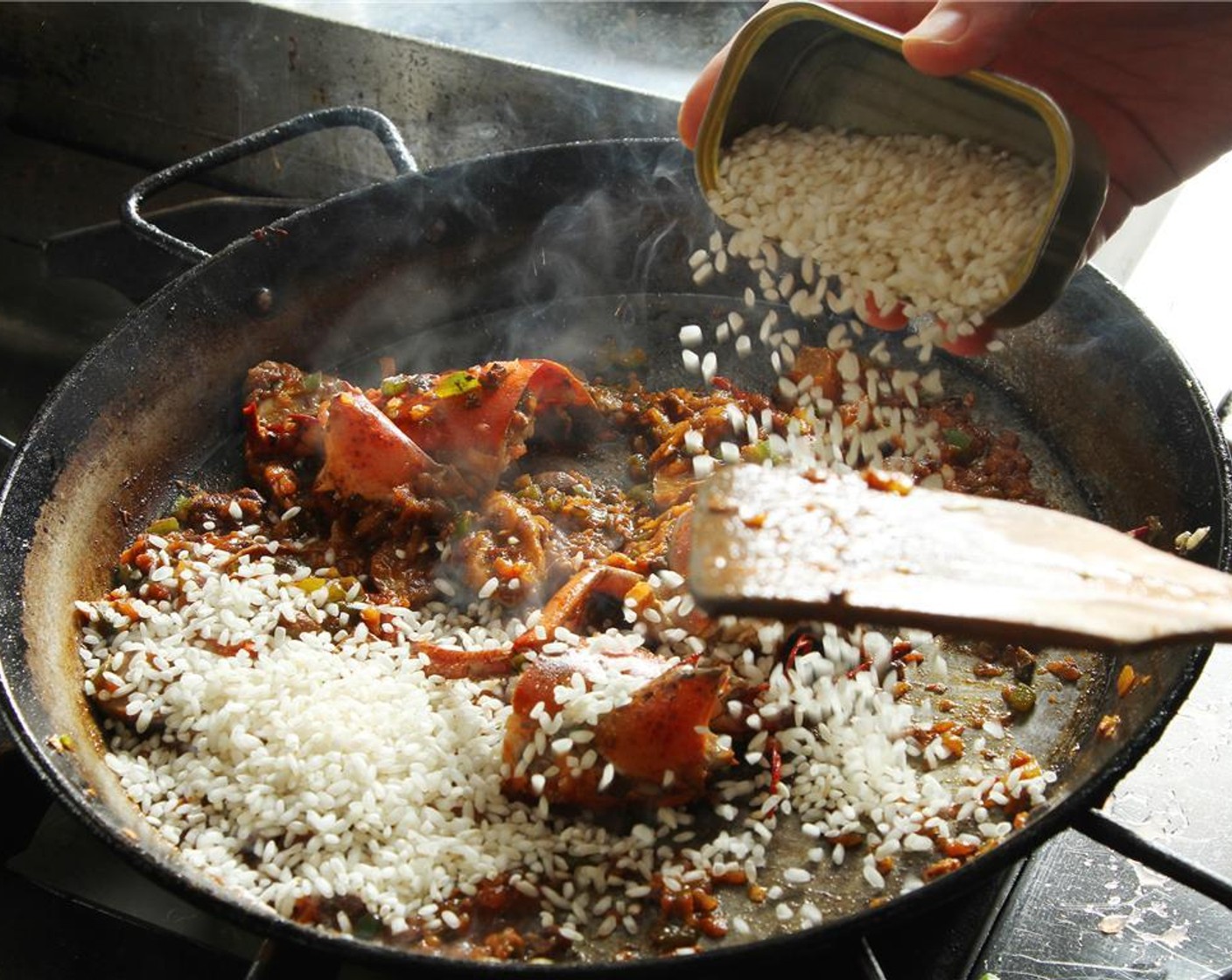 step 16 Add the Bomba Rice (3/4 cup), seal the grain by tossing the rice in the pan over high heat.