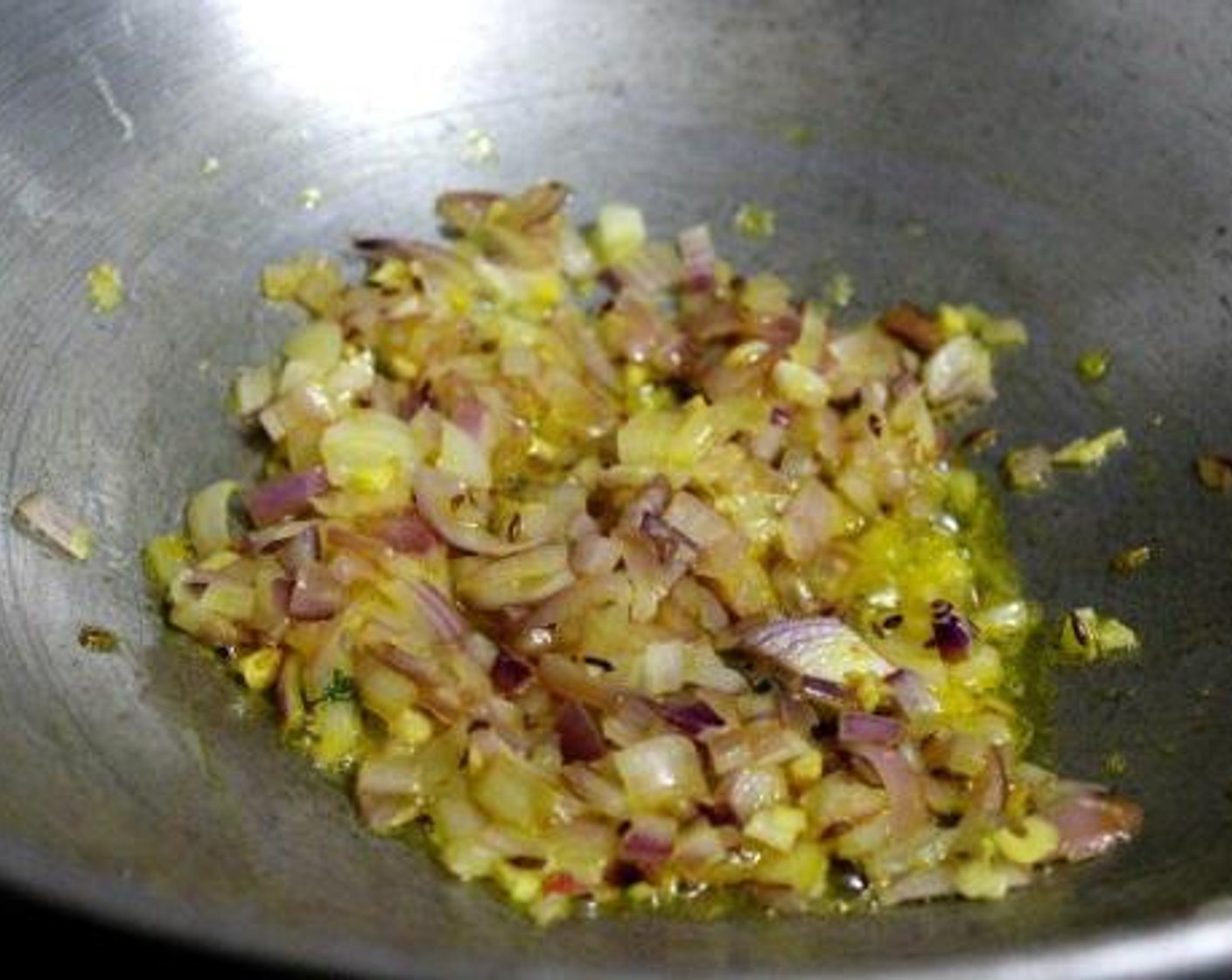 step 6 Heat Oil (1 Tbsp) in a pan and season with Cumin Seeds (1/2 tsp) and let it crackle. Add onions and chopped Garlic (6 cloves) and cook over medium flame till it becomes translucent.