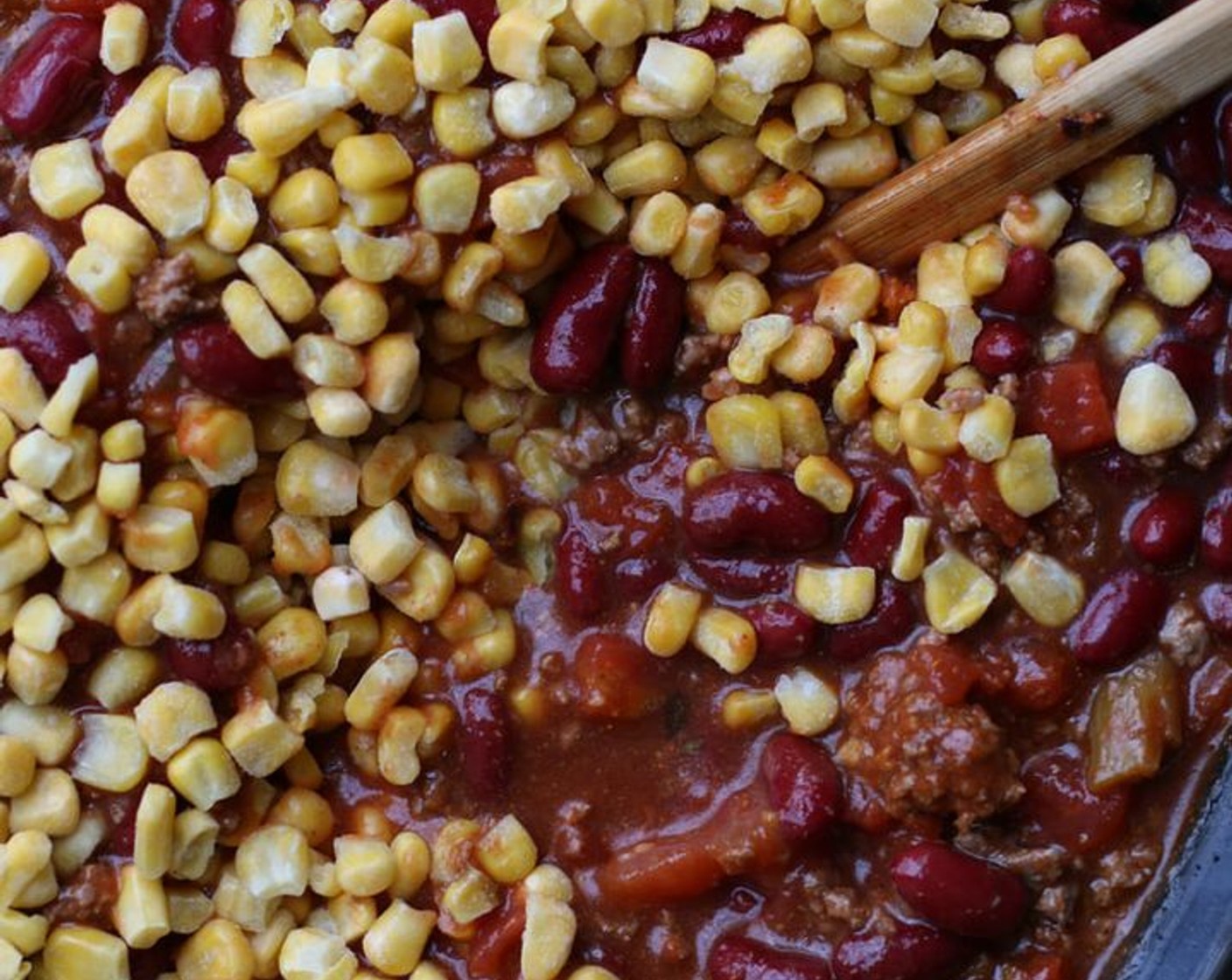 step 2 Add beef, Condensed Tomato Soup (1 can), Diced Tomatoes (2 cans), Corn (1 can), Chili Beans (1 can) (DO NOT DRAIN), and Red Kidney Beans (1 can), along with McCormick® Taco Seasoning Mix (1/3 cup) and Ranch Seasoning Powder Mix (1/3 cup) in a large slow cooker.