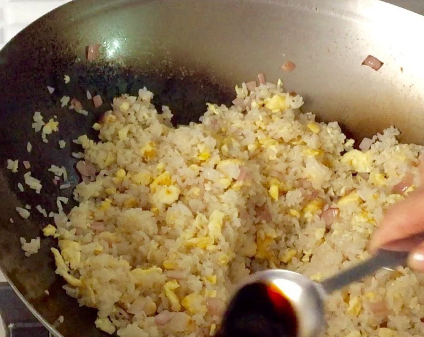 step 15 Next, pour in the Light Soy Sauce (2 Tbsp) around the edges of the wok and give it a quick stir fry.