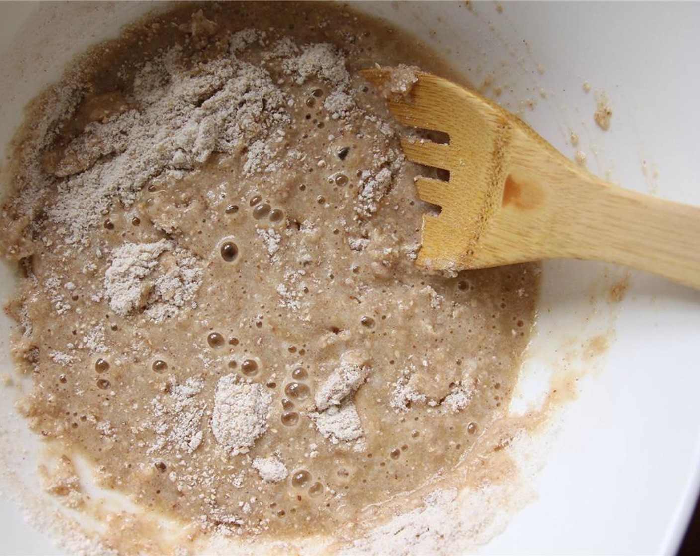 step 4 Pour the wet mixture into the dry ingredients and stir with a large wooden spoon until just combined, being careful not to overmix (stop when you no longer see dry flour).
