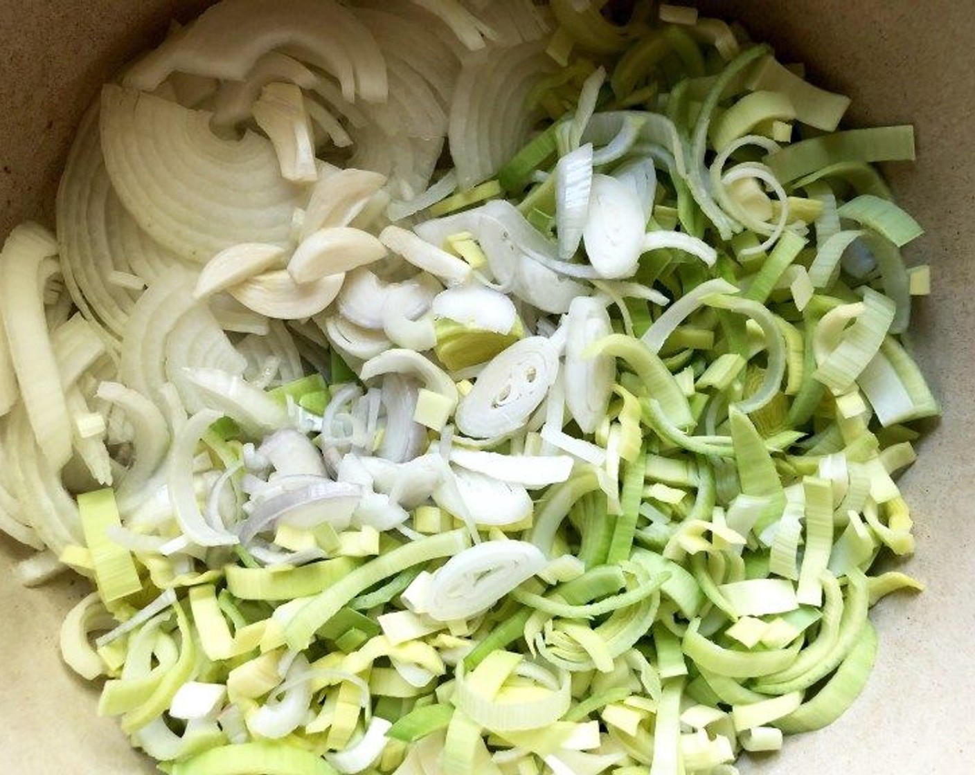 step 2 Add White Onion (1), Leeks (2 stalks), Frozen Green Peas (1 cup), Shallot (1), and Garlic (2 cloves) to the pot with the bacon drippings. Stir in a pinch of sugar and salt. Reduce the heat to low and cook, uncovered, for about 15 to 20 minutes or until softened and translucent.