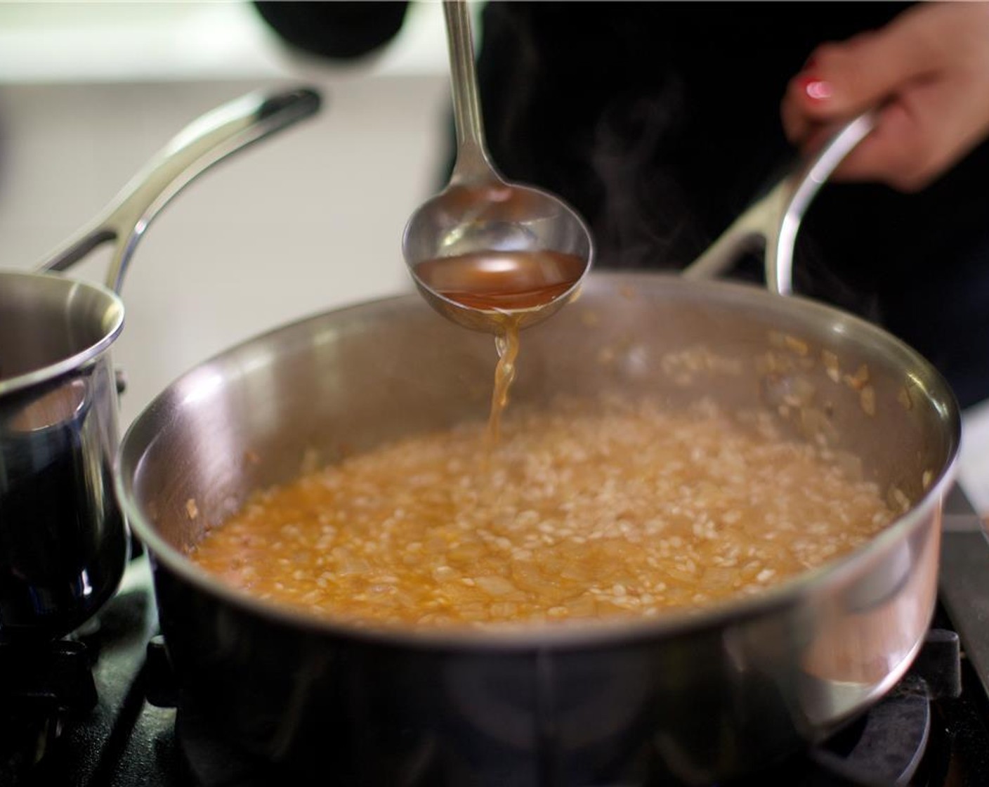 step 8 Add the White Cooking Wine (1/4 cup) to the rice and lower the heat to medium heat and simmer until the liquid is nearly absorbed, about 5 minutes.