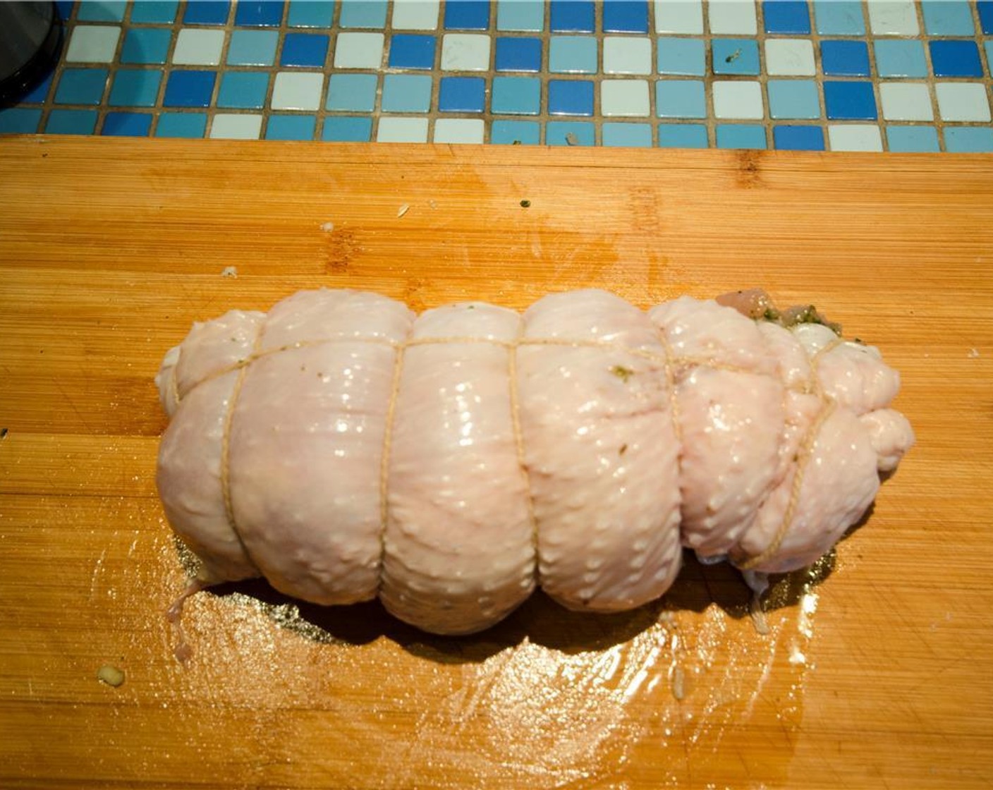 step 6 Carefully roll the turkey meat into a tight cylinder, using the skin to completely enclose it. Tie the roast tightly with butcher's twine at 1-inch intervals, as well as once lengthwise.
