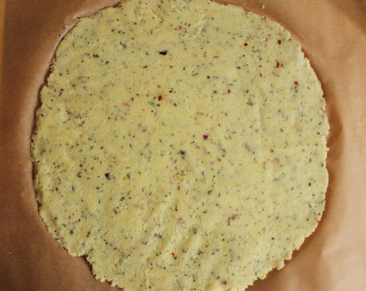 step 10 Remove the second sheet of parchment and briefly set your pizza aside while you prepare your vegetables.