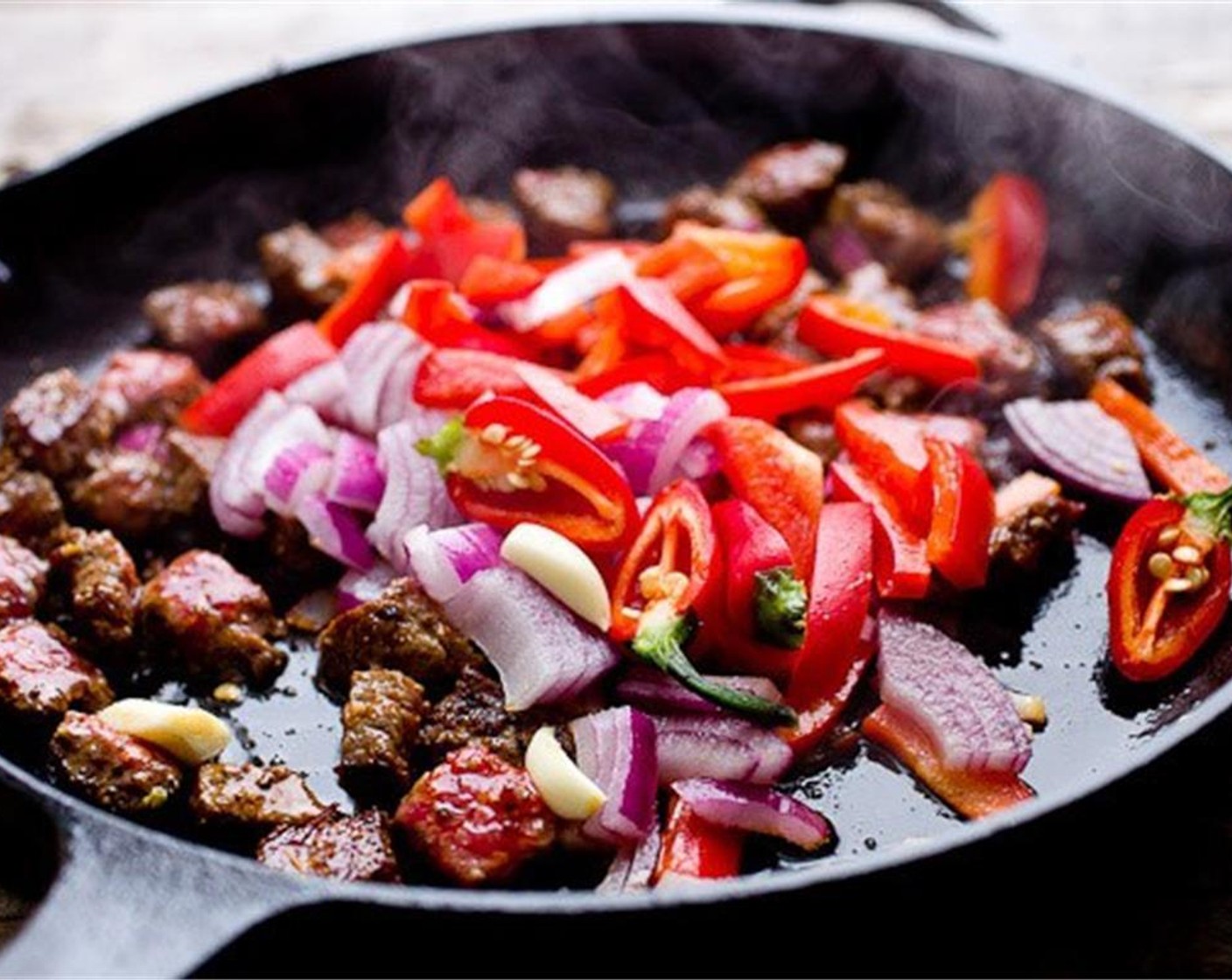 step 4 Add Red Chili Pepper (1/2), Red Jalapeño Peppers (2), Red Onion (1/4), Garlic (2 cloves). If the pan seems dry, add more Olive Oil (to taste). Cook for 1 to 2 minutes.