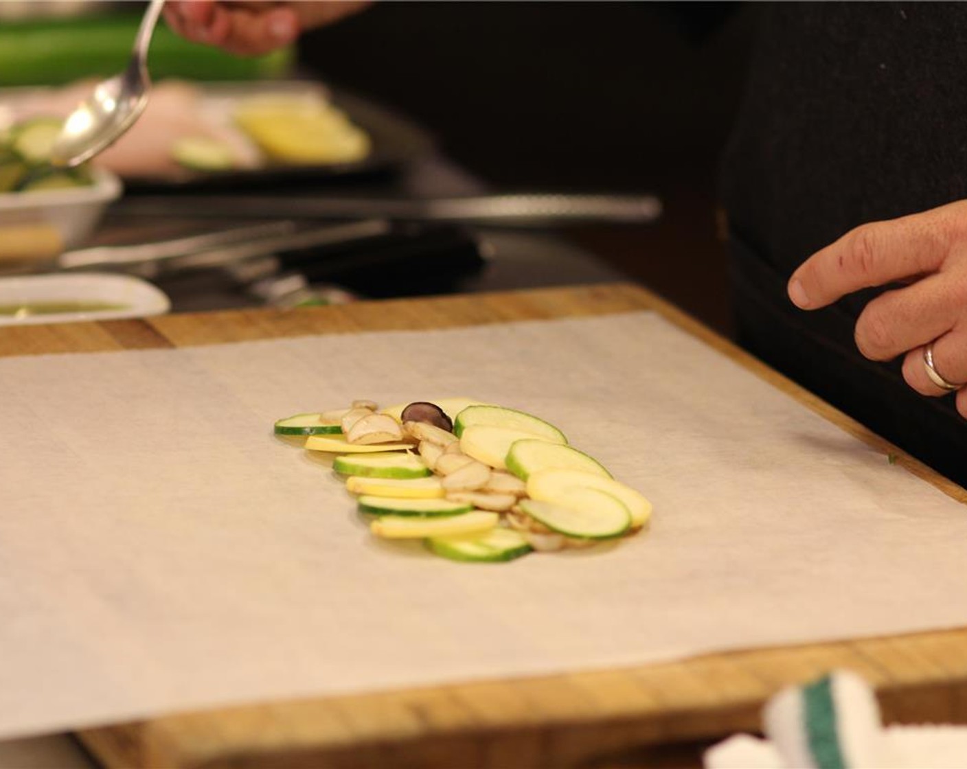 step 9 On a piece of parchement paper, lay the sliced potatoes, sweet pepper, gold bar zucchini, green zucchini and lemon. Season with Kosher Salt (1 pinch) and Ground Black Pepper (1 pinch). Repeat with the other packets, one per person.