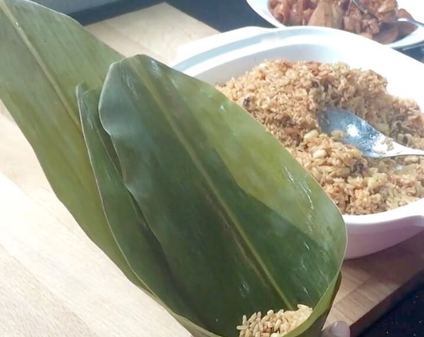 step 31 Then add in 1 heaped tablespoon of fried glutinous rice mixture. Fill about 1/3 of the cone with the glutinous rice mixture. Press down firmly with a spoon.