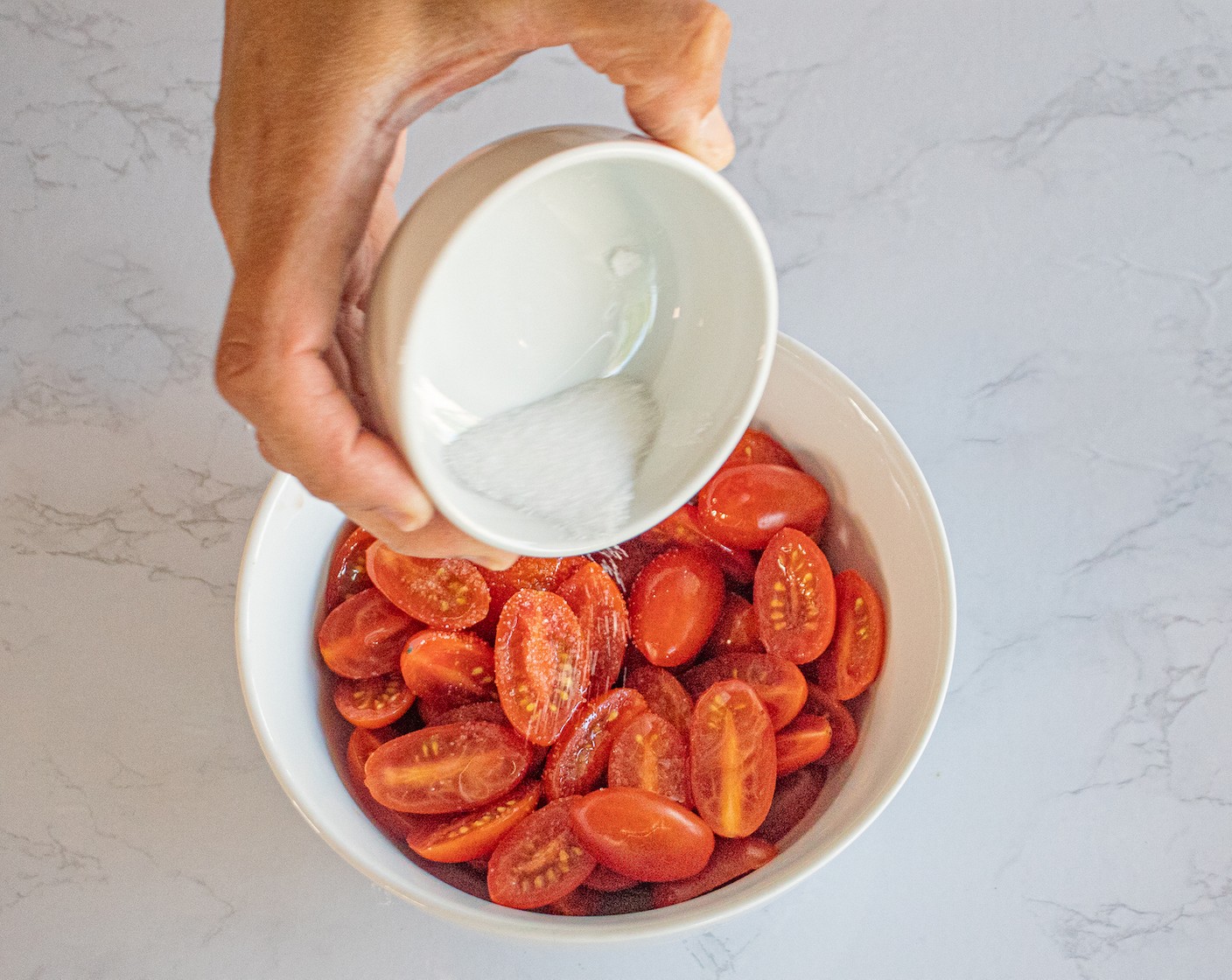 step 2 Add Olive Oil (4 Tbsp), Salt (1 tsp), Ground Black Pepper (1/4 tsp), and Cherry Tomatoes (2 cups) to a bowl and mix well.