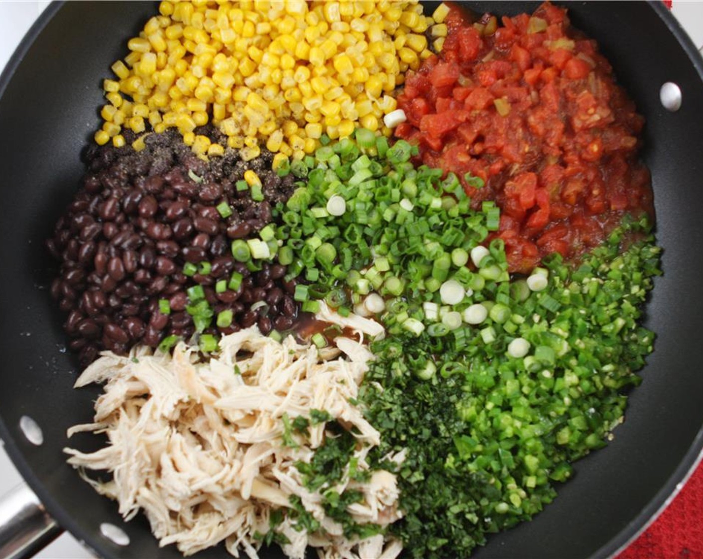 step 4 Add the Chicken (1 cup), Corn (1 can), Black Beans (1 can), Diced Tomatoes (1 can), Scallion (1 bunch), Fresh Cilantro (1/4 cup), juice from the Lime (1), Salt (to taste), and Ground Black Pepper (to taste) to the skillet. Cook mixture over medium-low heat for about 5 minutes, stirring frequently.
