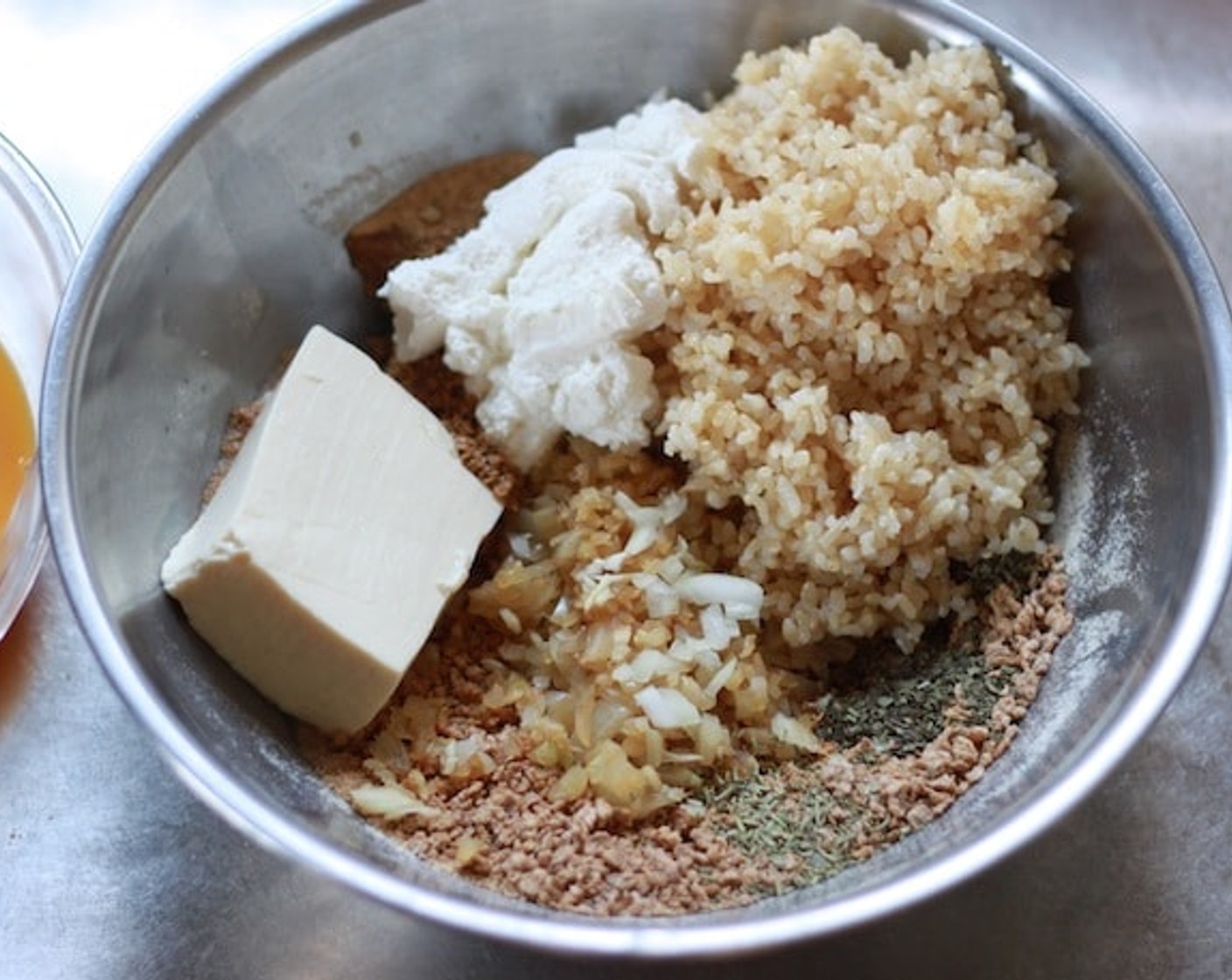 step 8 Put the vegetable soup you made earlier, Light Ricotta Cheese (2/3 cup), Firm Tofu (5.5 oz), sauteed garlic and onion, cooked brown rice, Fresh Oregano (1 tsp), Fresh Basil (1 tsp), and Fresh Rosemary (1/2 tsp) into a crushed flakes bowl.