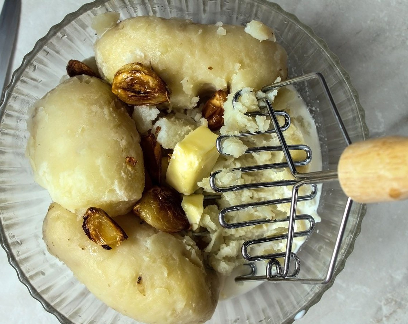 step 12 In a bowl, combine the roasted garlic, Milk (1 cup), Butter (2 Tbsp) and potatoes and start mashing! Mash it lots for a creamier mashed potato, and mash it less for a chunky rustic mashed potato.