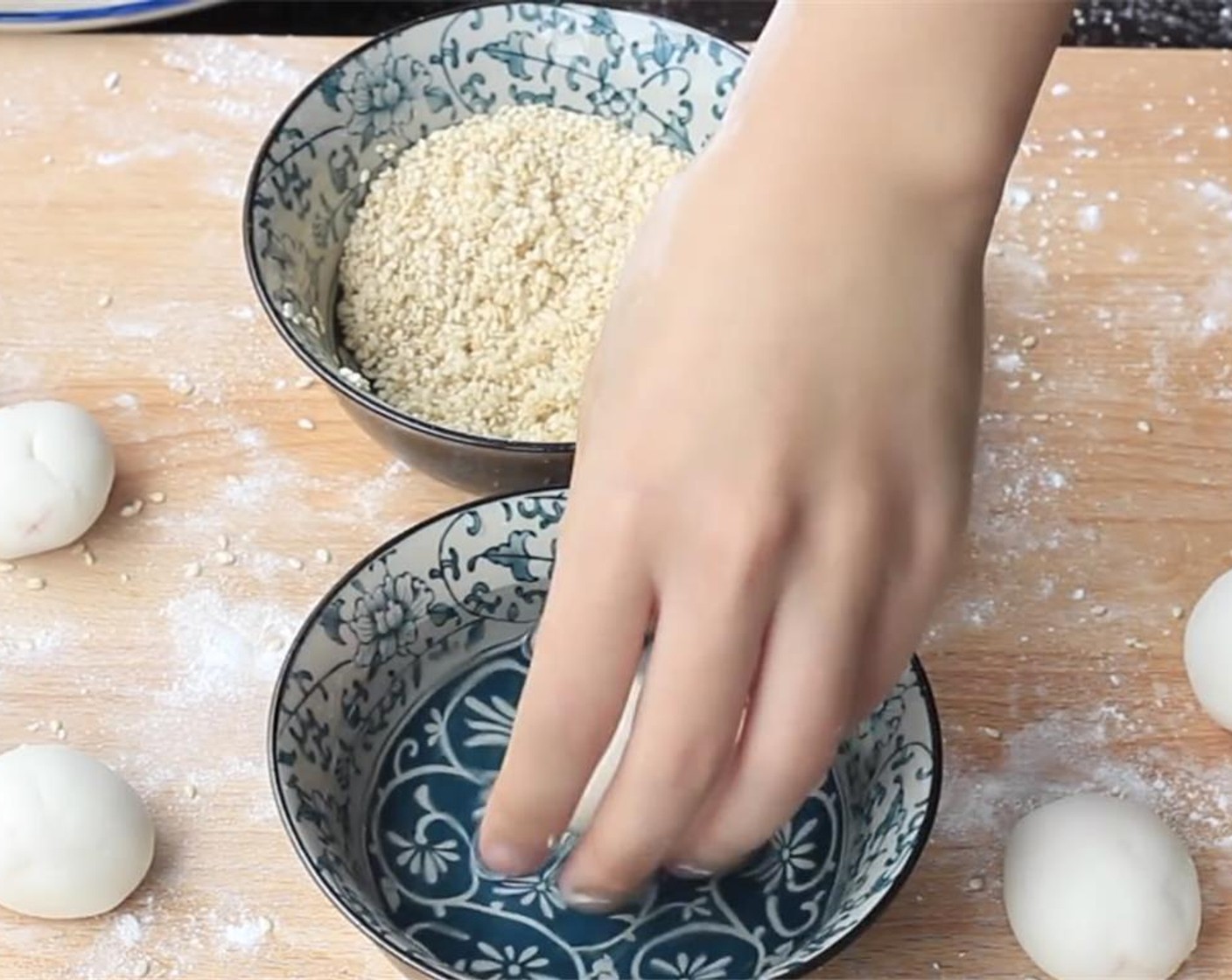 step 5 Prepare two bowls, one with Water (1/3 cup) and the other with Roasted White Sesame Seeds (1 cup). Take one ball with one hand and quickly dip the balls in water and then roll the balls the sesame bowl with the other hand.