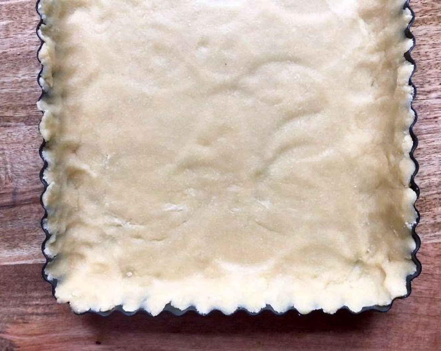 step 4 Crumble to distribute evenly in an 11 by 8-inch rectangular tart pan or an 11-inch round pan with removable bottom. Press into the pan so that the dough fills in the corners and is flush with the top edges. Alternatively, gather the dough into a ball and flatten. Roll out the dough between two pieces of parchment paper into a 12 by 9-inch rectangle. Transfer the dough to the tart pan. Press into corners and trim excess.