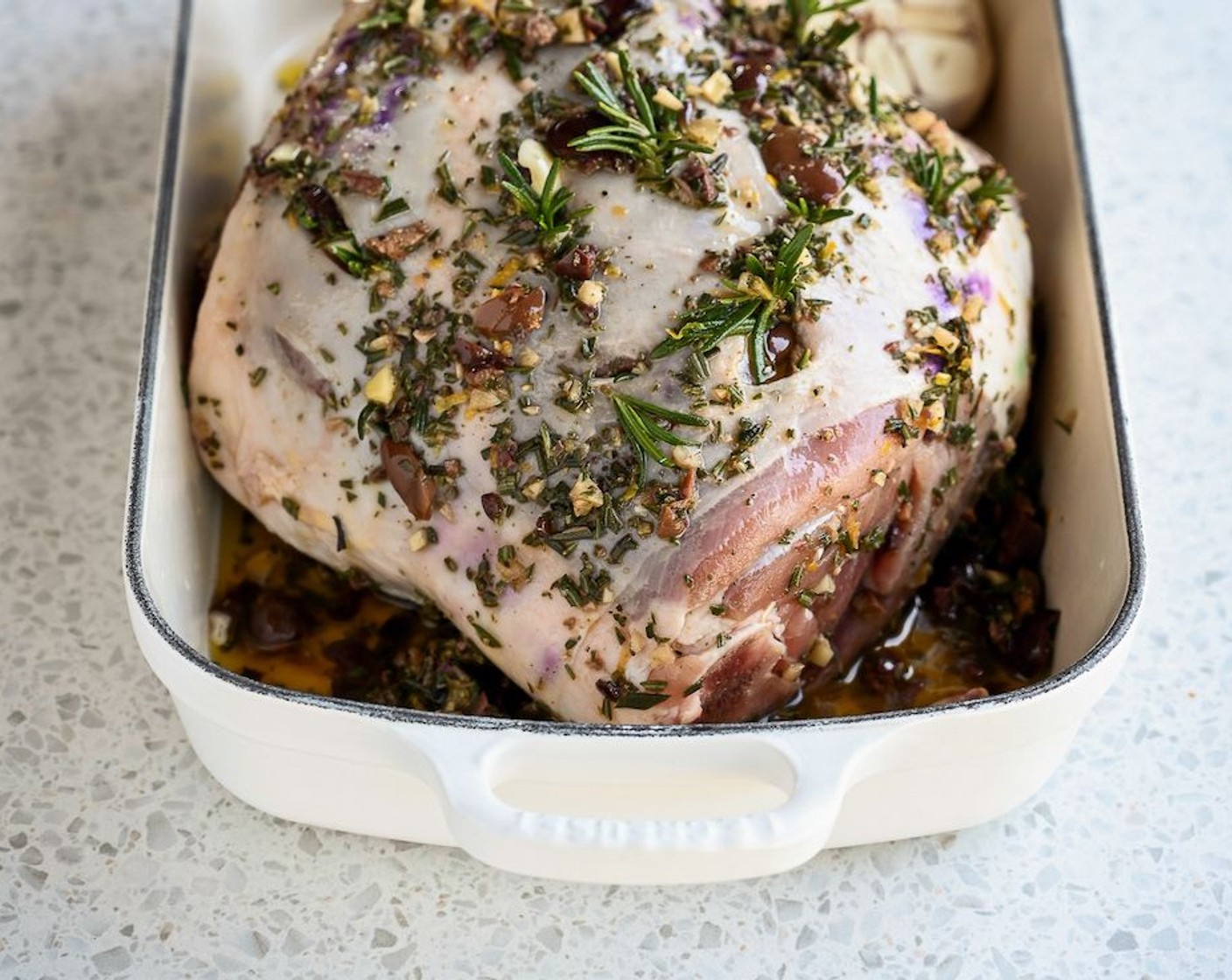 step 6 Arrange this and the remaining Fresh Rosemary (5 sprigs) on the bottom of a large roasting pan. Lower the lamb on to this grid and pour over the marinade. Season the lamb with Coarse Sea Salt (to taste), Ground Black Pepper (to taste), and pour in the Dry White Wine (2 cups).