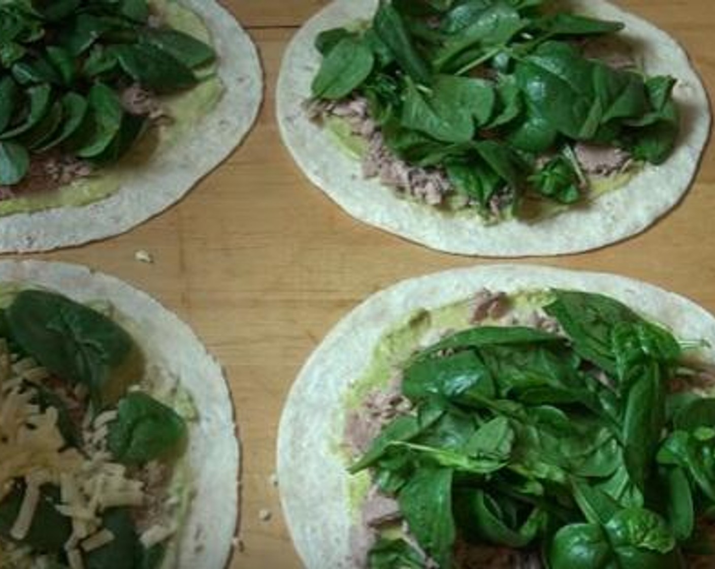 step 2 Divide the avocado mixture between four of the Tortillas (8). Using the back of the spoon, spread out the avocado over the surface. Also, divide the Canned Tuna (1 3/4 cups) among the four tortillas.Top with Fresh Baby Spinach (1 2/3 cups),and Cheddar Cheese (1 cup).