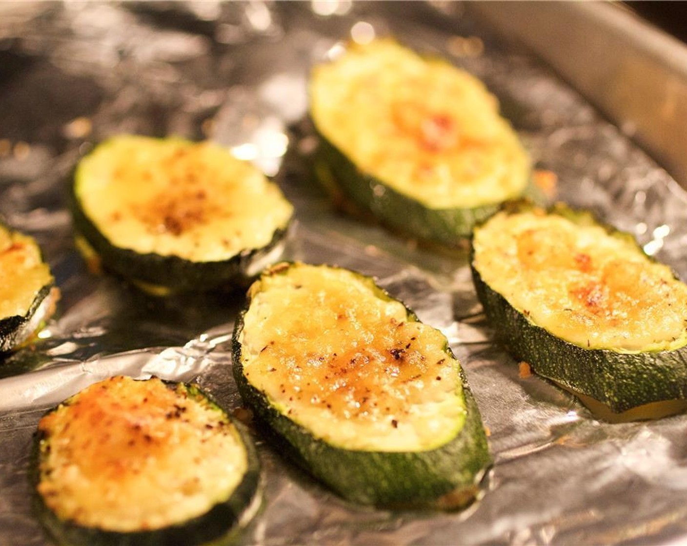 step 6 Meanwhile, drizzle Olive Oil (1 tsp) over the zucchini. Sprinkle Parmesan Cheese (2 Tbsp), Salt (1/4 tsp) and Ground Black Pepper (1/4 tsp) over the zucchini. Roast in the oven for 9 minutes.