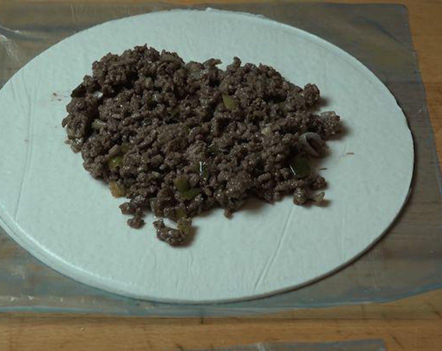 step 5 Take Puff Pastry (4 sheets) and using a bowl as a guide and knife cut into large circles. Add a quarter of the beef mixture into the center of the puff pastry circle. Crack Egg (1) into a small container and beat. Using the eggwash paint the edges of each circle.