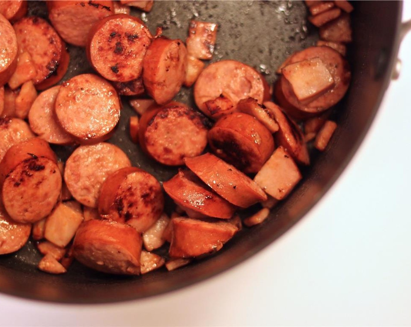 step 2 In a very hot large pot, add Olive Oil (1/2 Tbsp), Smoked Turkey Kielbasa (1 pckg) and Canadian Bacon (5 slices). Cook until brown.