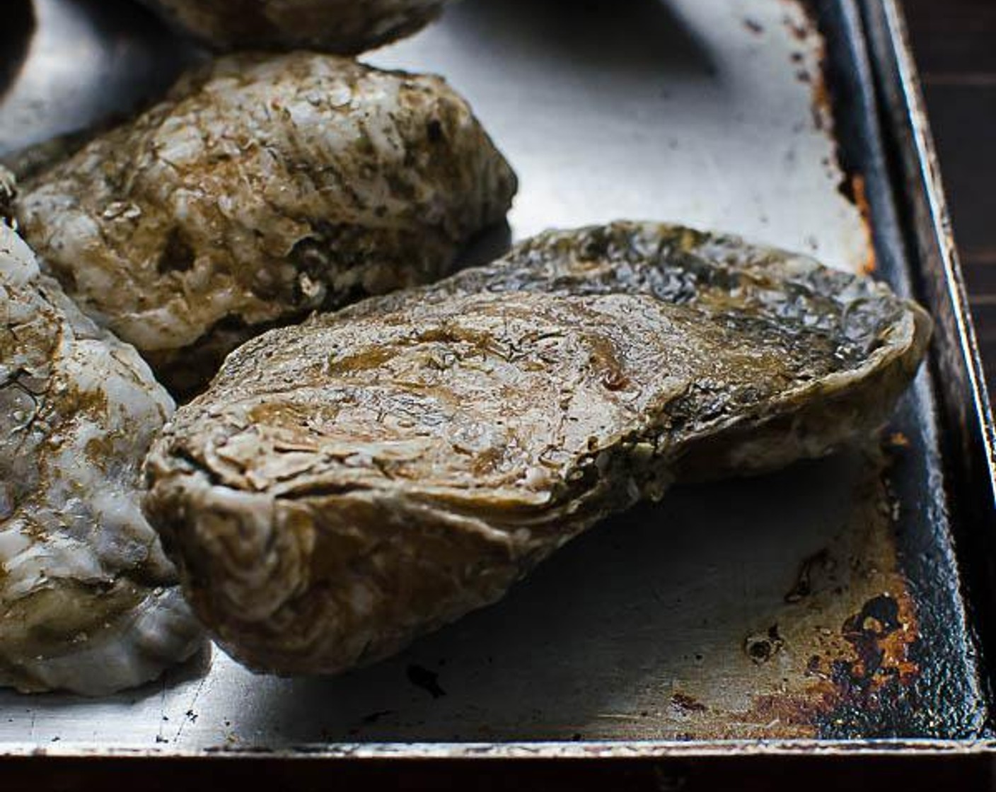 step 6 Place the oysters flat side up on the hot grill (you don't want the oyster liquor to escape, so make sure the rounded side is resting on the grill grates). Cook on the grill for 3 to 4 minutes, just until the oysters crack open slightly. Transfer the oysters to a platter.