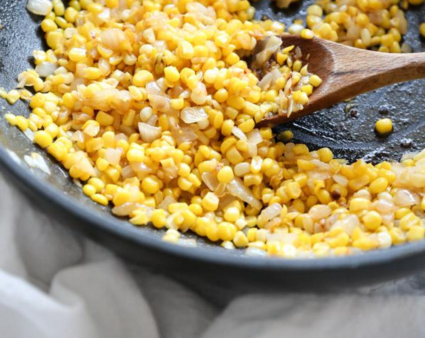 step 2 In a large skillet, heat the Olive Oil (2 Tbsp). Saute the Corn Kernels (3 cups) and Yellow Onion (1) over medium-high heat, stirring occasionally, until beginning to caramelize, about 5 minutes.