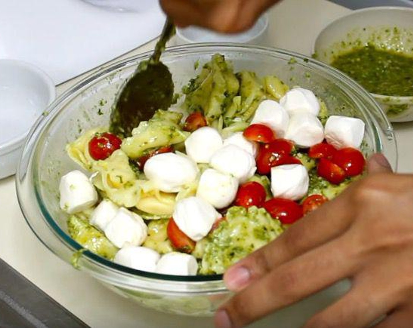 step 2 In the mixing bowl, add Basil Pesto (1 cup), Cherry Tomato (3/4 cup), and Fresh Mozzarella Cheese Ball (24). Mix together.