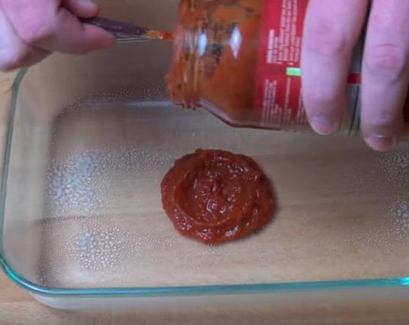 step 4 In a lightly greased 20x30-centimeter glass baking dish, spread Tomato Sauce (1 cup) over the base.
