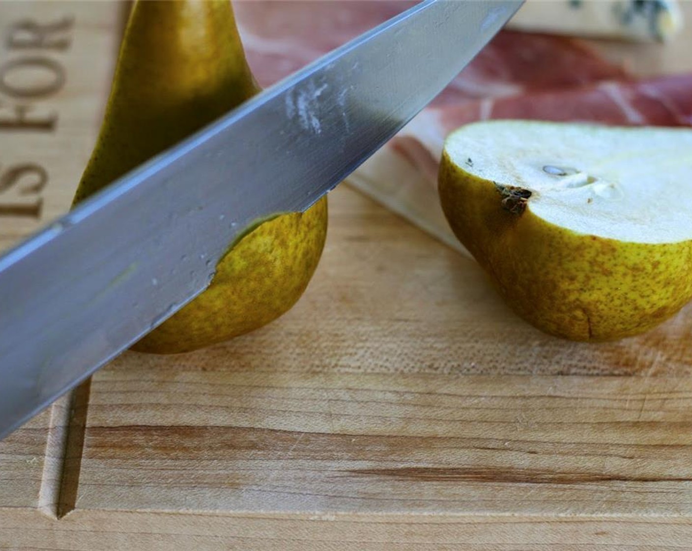 step 4 Slice the Pears (2) in half and remove seeds and core. Shave off a small piece of the rounded portion so that the pears sit flat. Drizzle with Olive Oil (as needed).