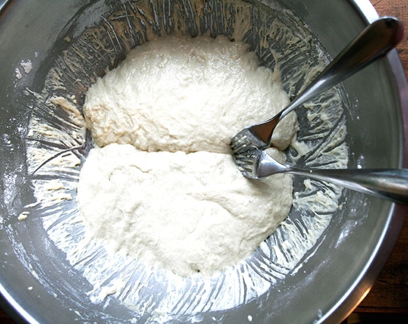 step 7 Then, take your two forks and divide the dough into two equal portions. To do so, eye the center of the mass of dough, and starting from the center and working out, pull the dough apart with the two forks. Scoop up each half and place into your prepared bowls.