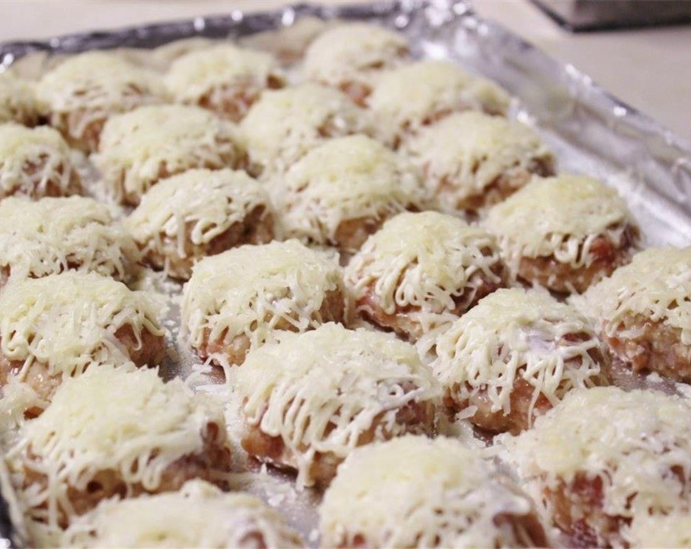 step 10 Combine the two cheeses together and sprinkle about 1/2 tablespoon on each meatball.