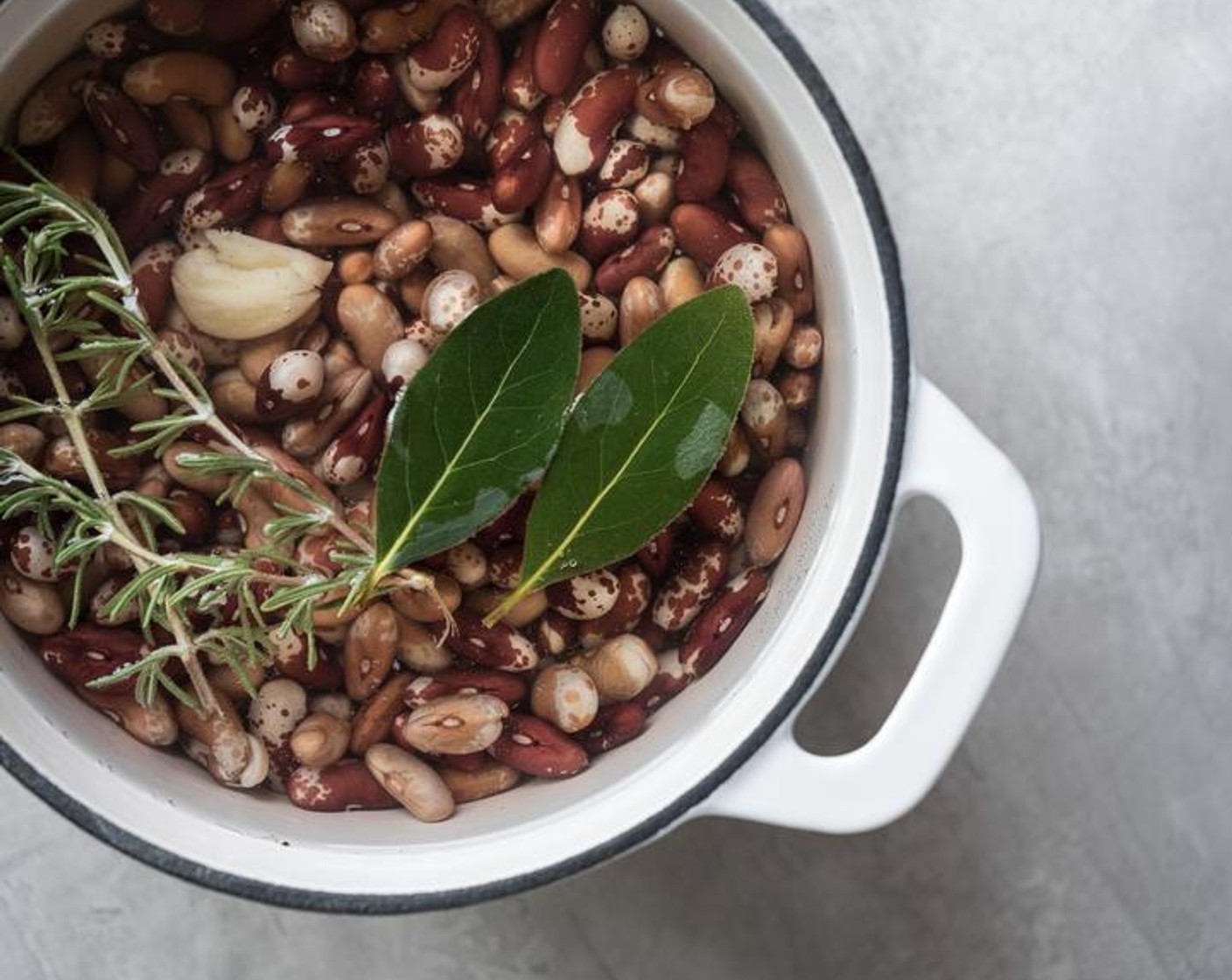 step 2 Drain soaking liquid from beans, add beans to a medium stockpot with plenty of water to cover them. Put in Salt (1 tsp), Garlic (1 clove), Bay Leaves (2 pieces), and Fresh Rosemary (2 sprigs).