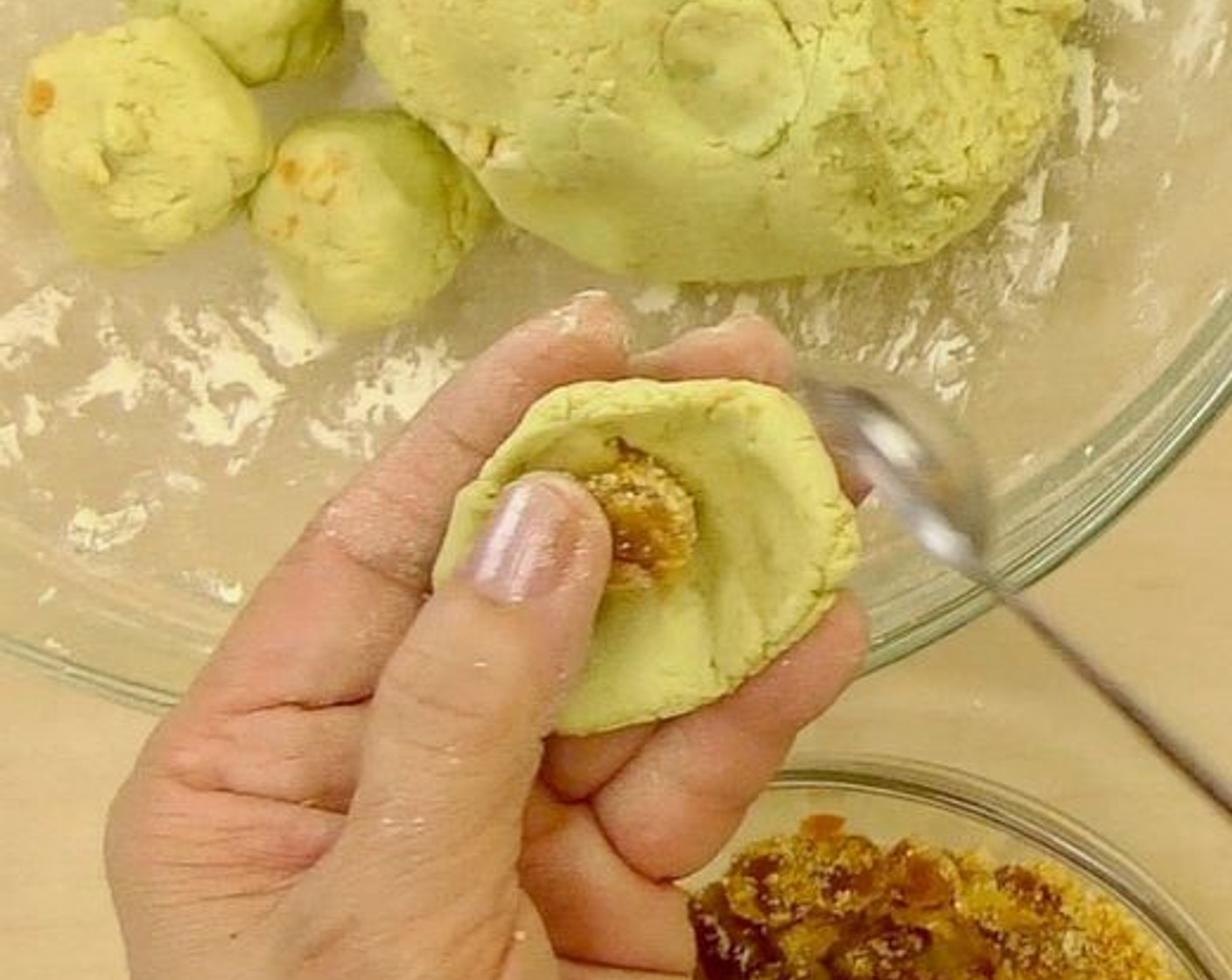 step 5 Divide into small doughs and wrap each dough with palm sugar filling. Then roll into balls. And we're ready to cook the filled onde-onde. Be sure to seal the balls of dough. Otherwise, the palm sugar will ooze out when boiled.