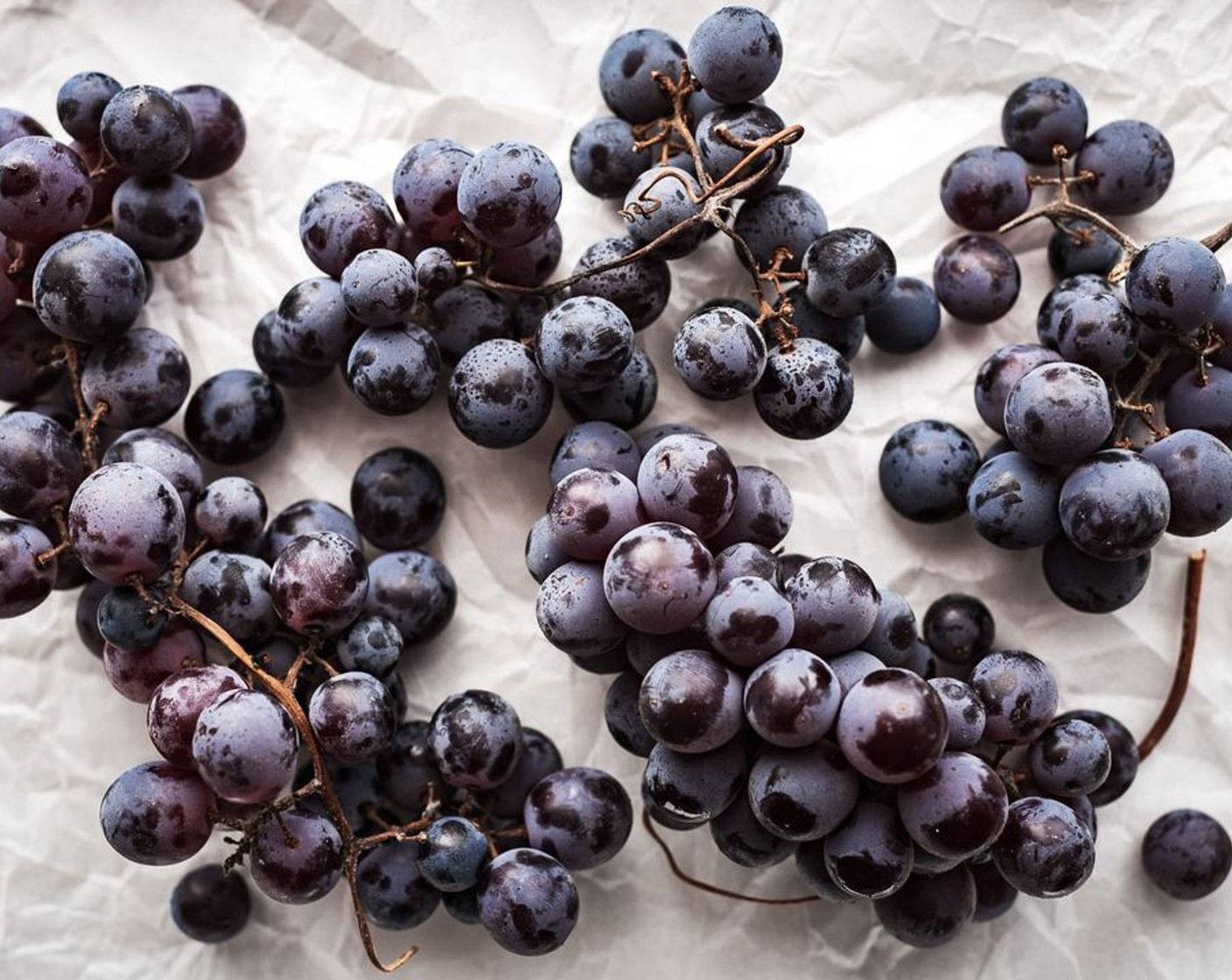 step 2 Arrange grapes onto one of the parchment-lined sheet pans, drizzle grapes with olive oil and season with a pinch of salt.