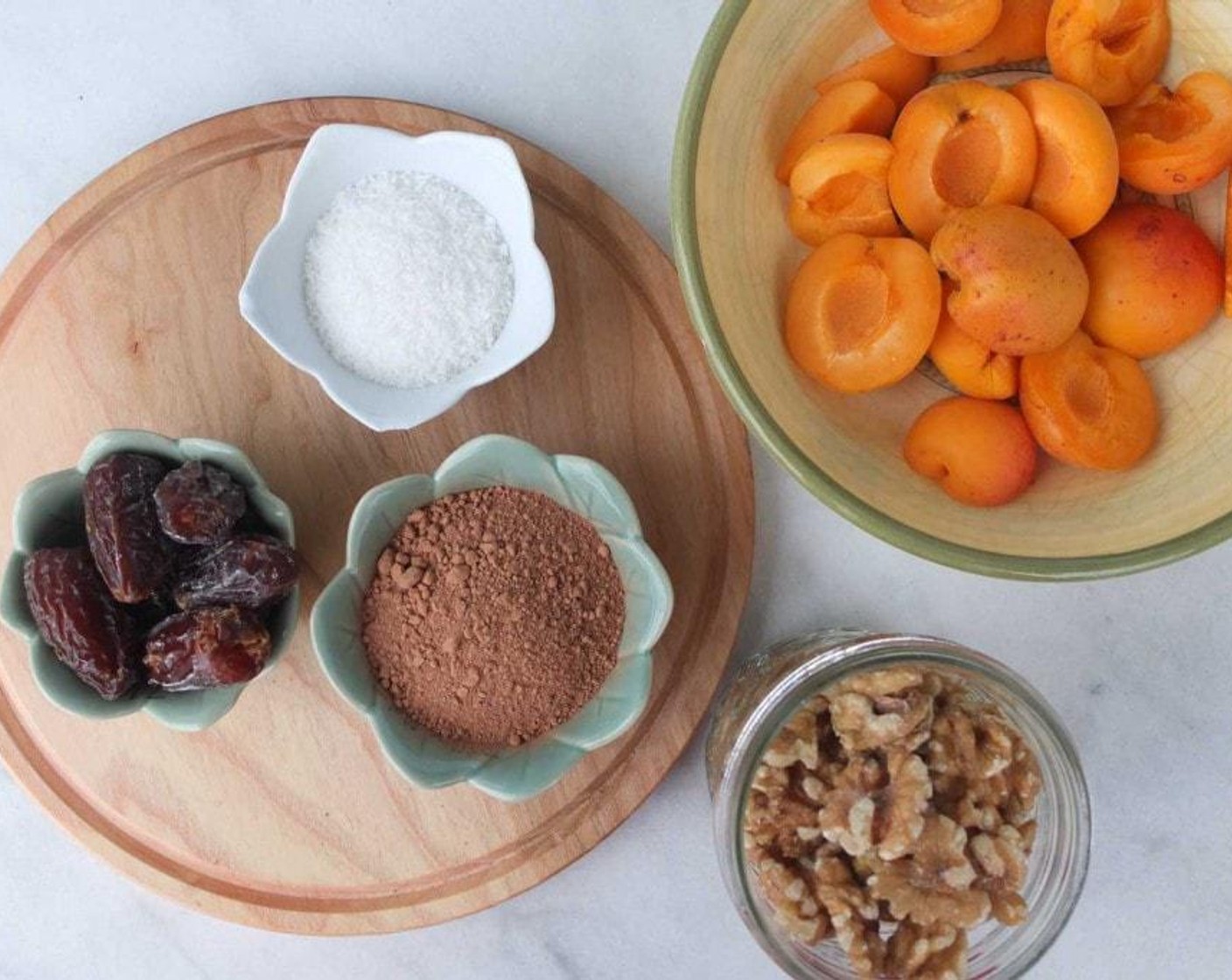 step 1 Place Medjool Dates (12), Walnuts (2 cups), Unsweetened Shredded Coconut (1/4 cup) and Raw Cacao Powder (1/3 cup) into a food processor or high powered blender. Blend until it forms a smoother texture, but still a bit crumbly.