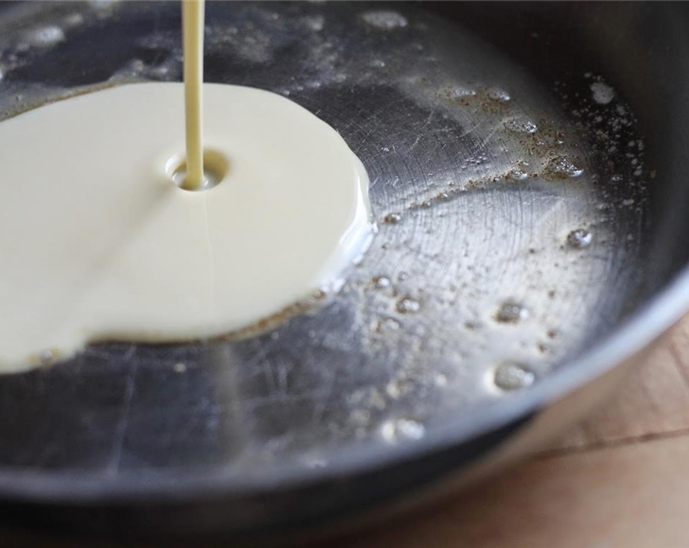 step 4 Pour a 1/4 cup of batter into the center of the pan.