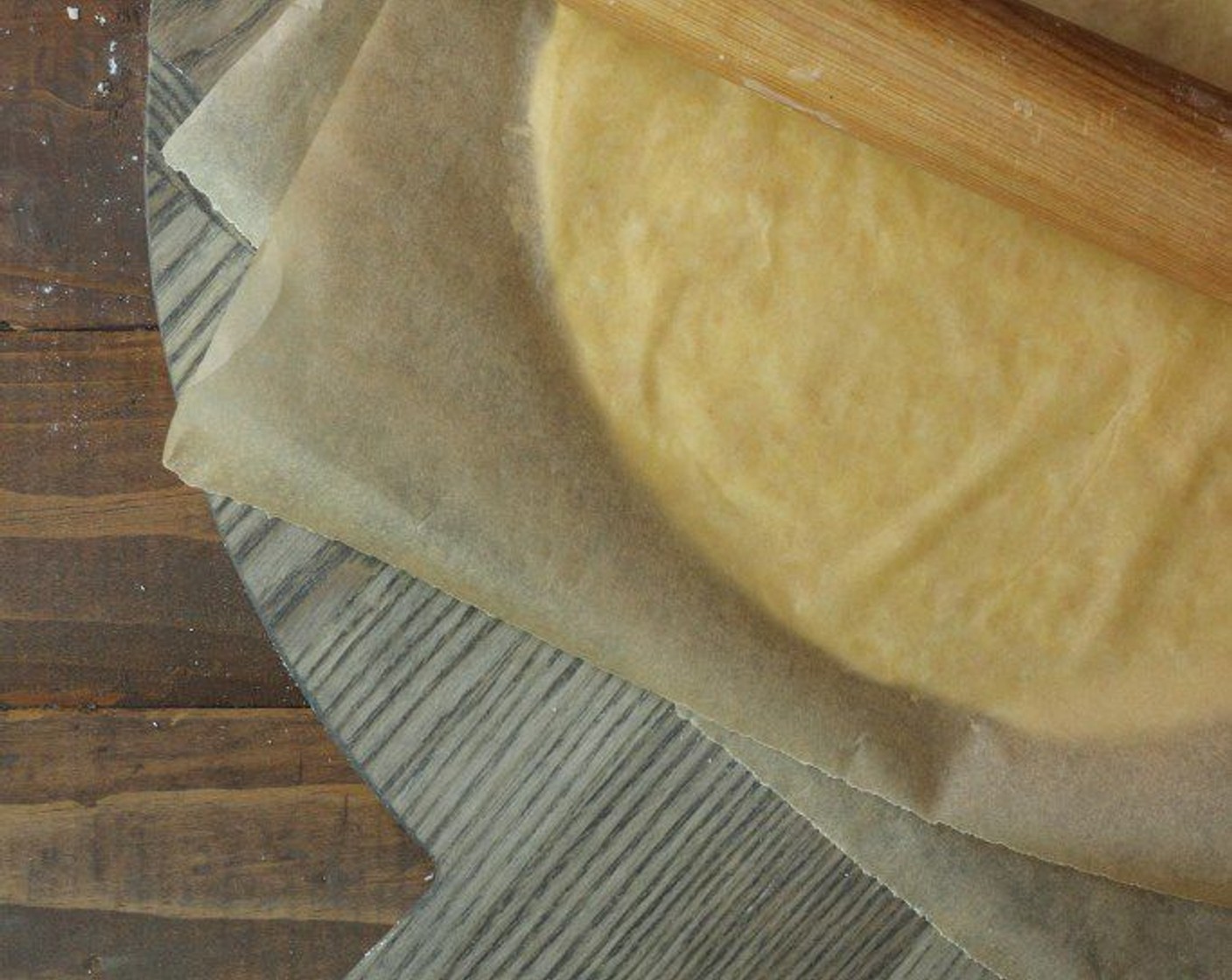 step 14 Place dough in between two sheets of parchment and using a rolling pin, gently begin to roll dough into a disc, alternating directions of the rolling pin.