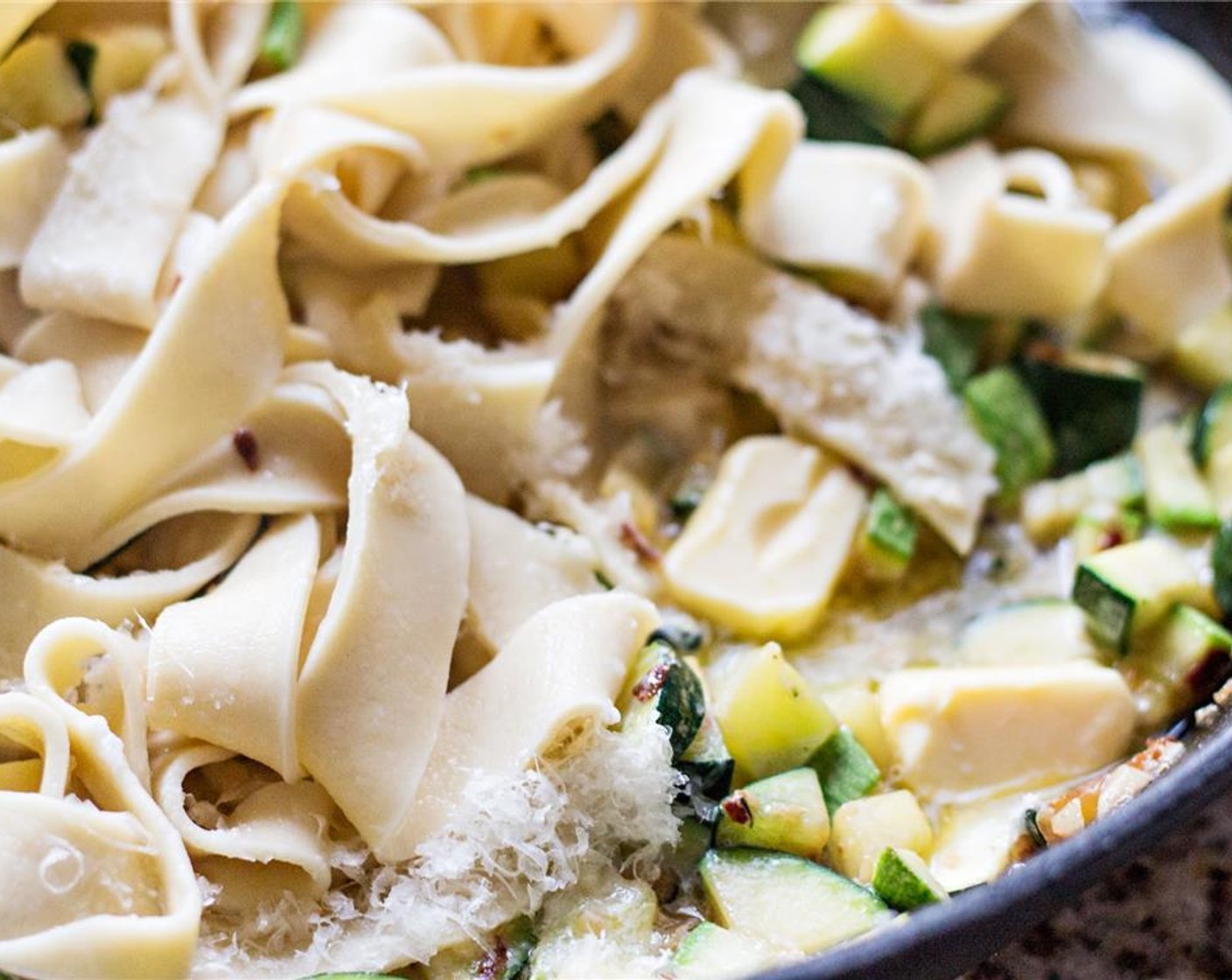 step 6 Drain the cooked fettuccine and add it to the zucchini pan along with the rest of the Butter (3 Tbsp), Cream (1/4 cup) and most of the Romano Cheese (1/2 cup). Toss the fettuccine around the pan to get everything mixed. Add Salt (to taste) and Ground Black Pepper (to taste).