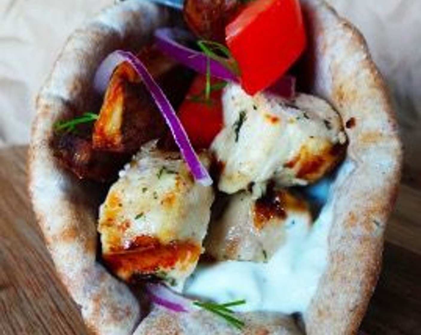 step 13 To assemble, spread a spoonful of tzatiki on the center of a slice of Pita Bread (4 slices). Top with chicken, Red Onion (1), and Roma Tomato (1). Enjoy!