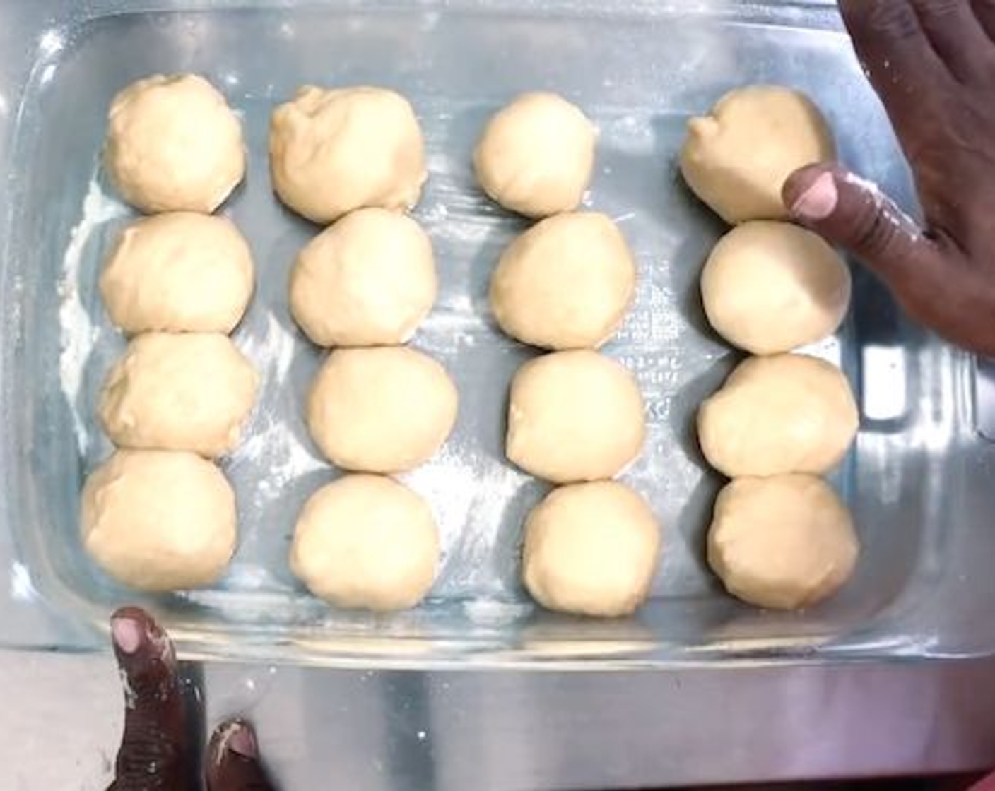 step 8 Create 16 dough balls about 60 grams each. Sprinkle some flour on your surface. Gather the outside edges and pinch towards the bottom, roll so they have a smooth top and a small crease in the bottom. Place in your baking dish and let it sit for 45 minutes.